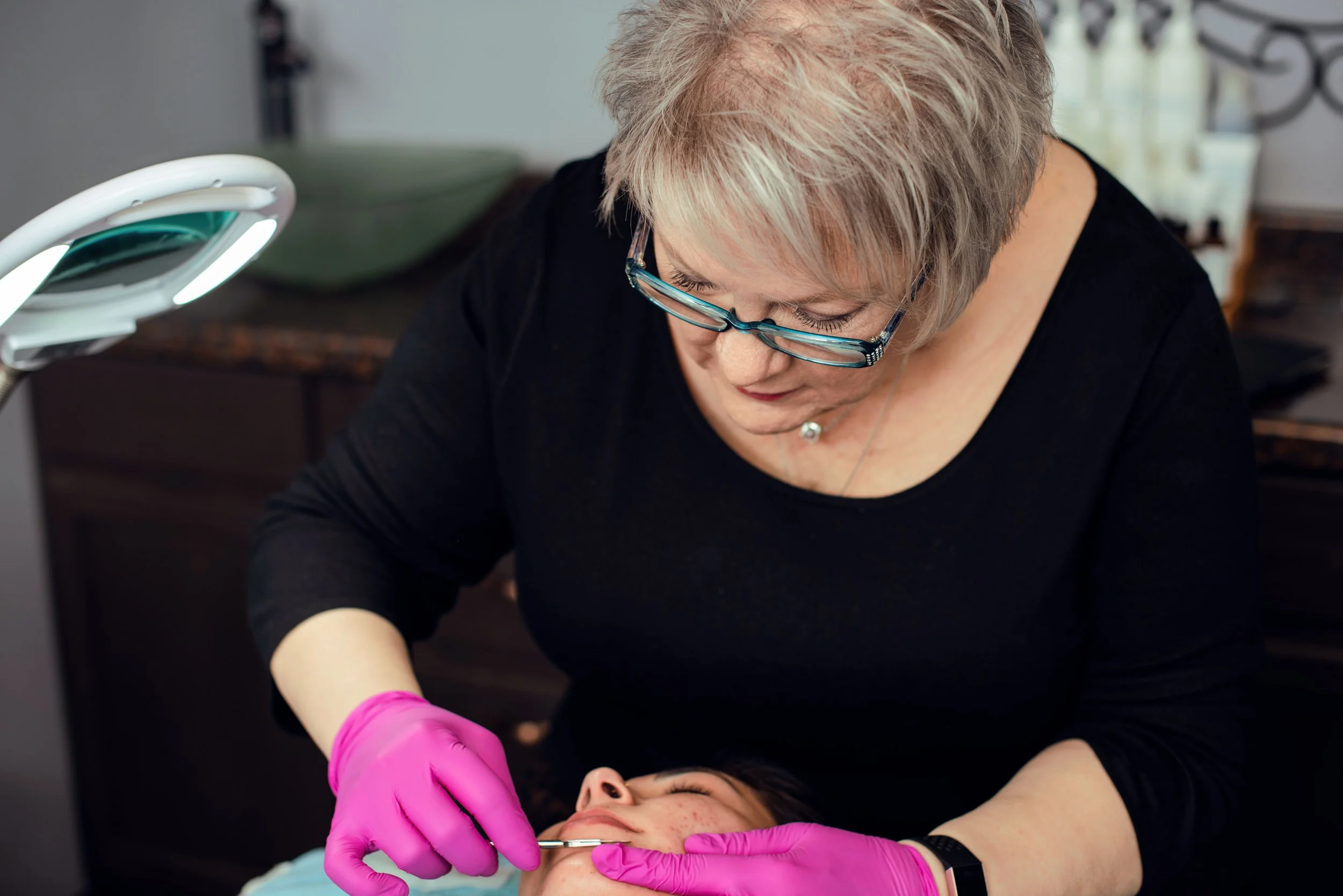 An esthetician in Wichita, KS, performing a customized cosmetic procedure on a client's face.