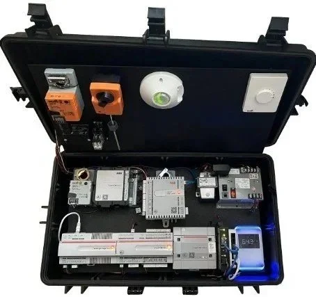 Open black carrying case with various electronic modules and components inside, including relays, a timer, and a digital display.