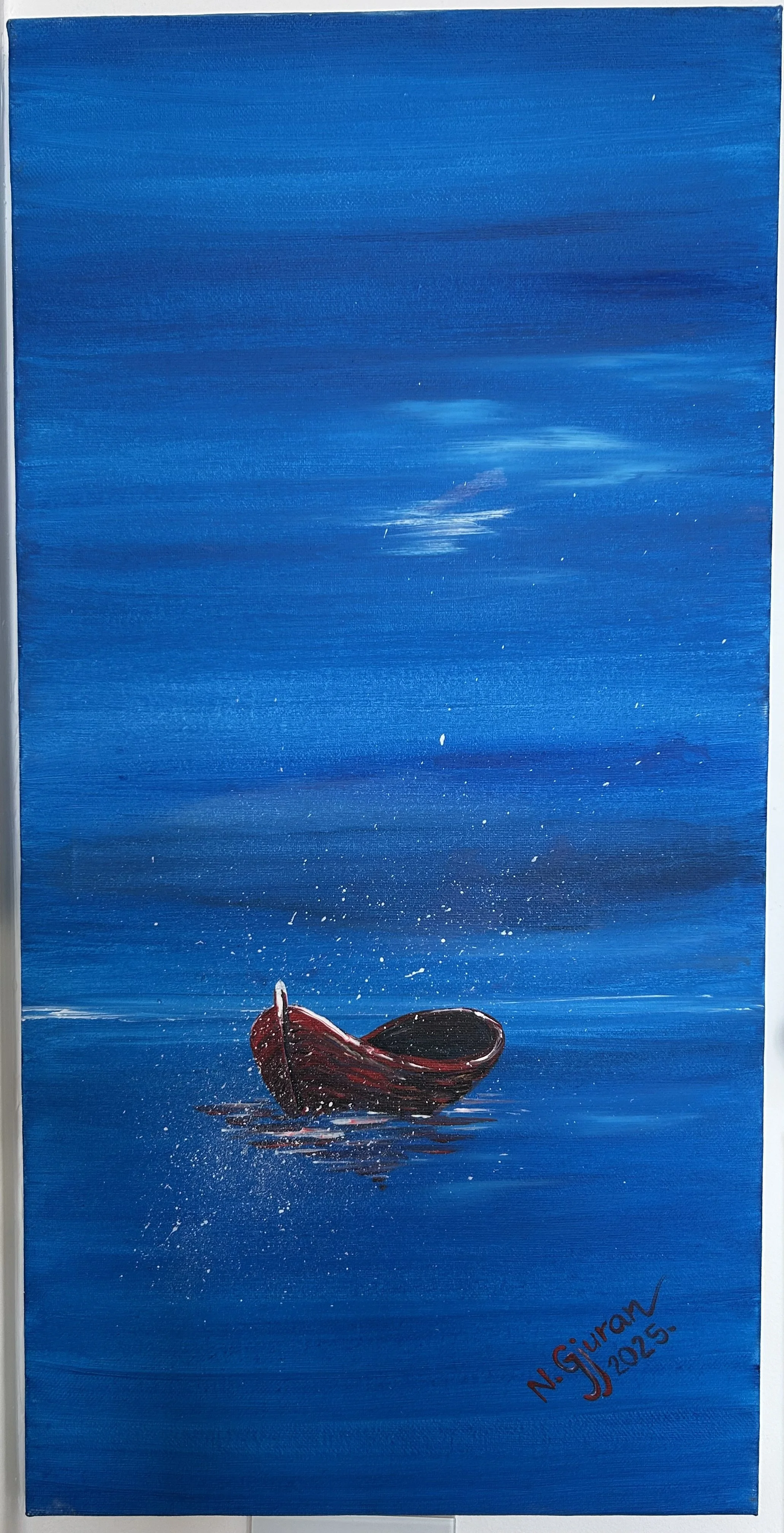 A painting of a small boat floating on a calm blue sea under a matching blue sky with subtle cloud streaks. The boat is dark red with white accents. Signed by N. Guran in 2023.