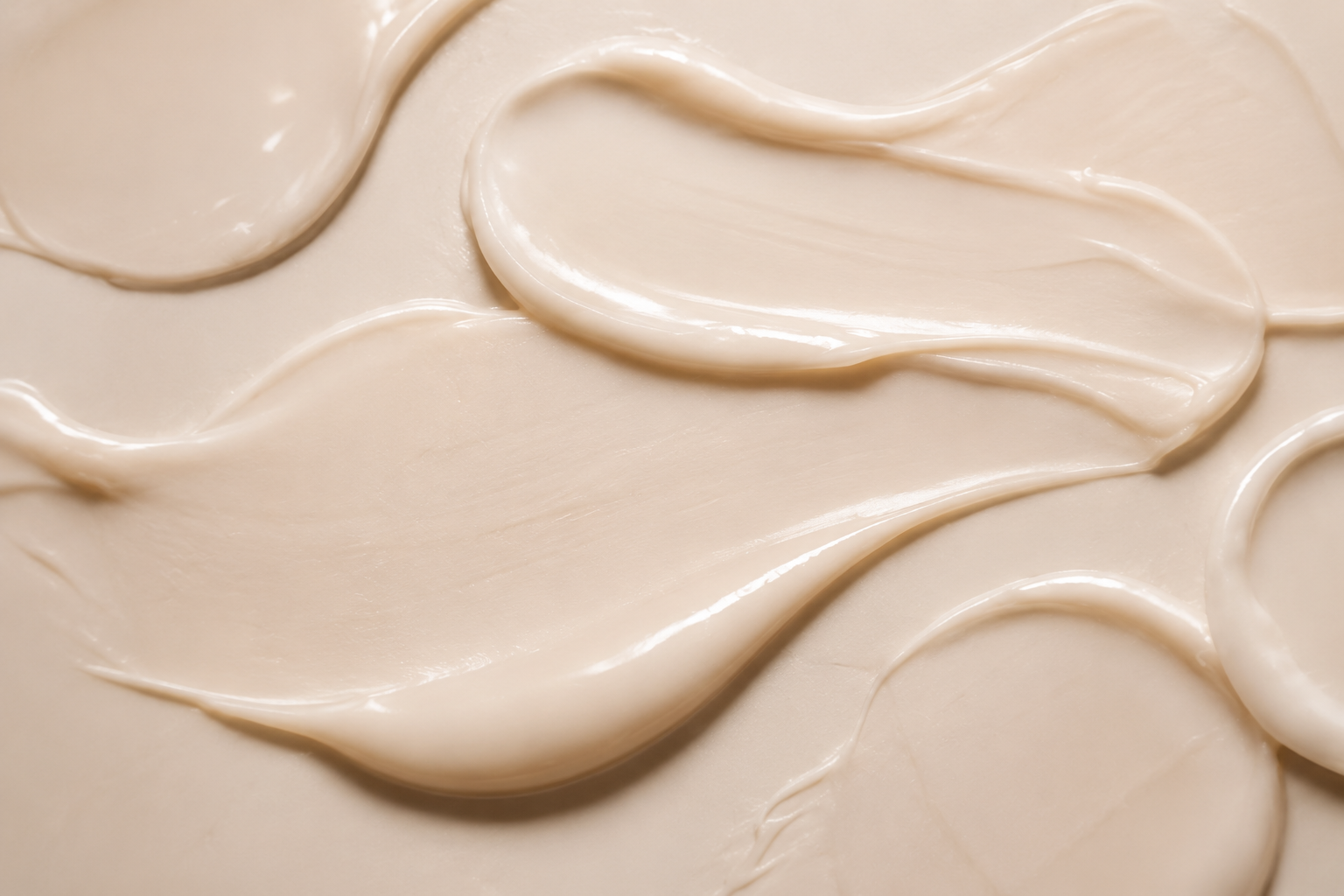 Close-up of smooth, creamy white substance, possibly lotion or cream, with swirled and textured surface.