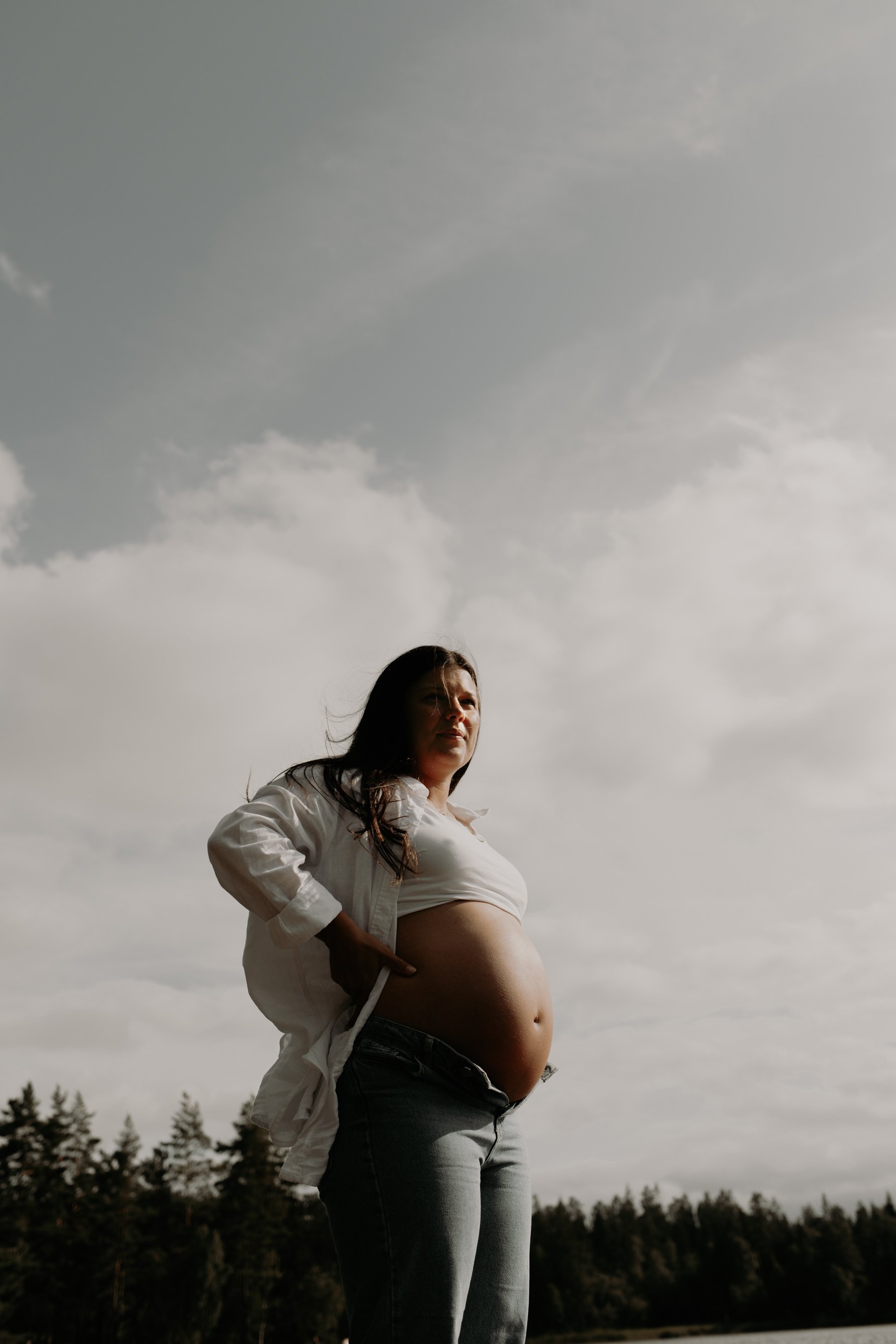 Gravid står på klipporna på västkusten