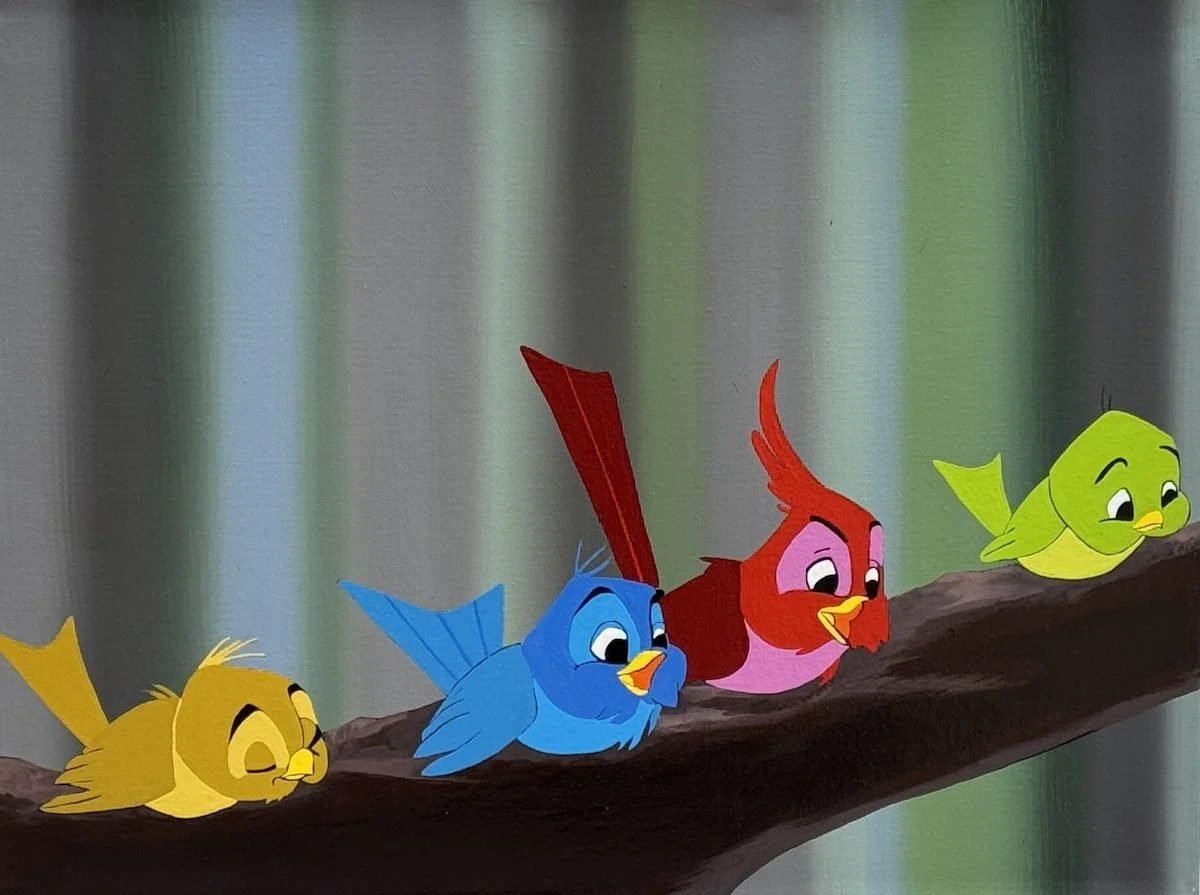 Four colorful animated birds sitting on a tree branch, smiling and looking at each other.