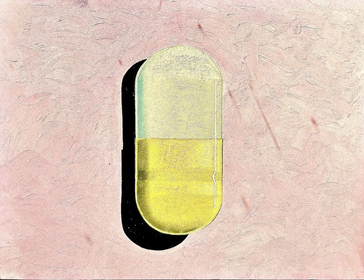 A capsule-shaped pill with a yellow lower half and a clear upper half, casting a shadow on a pink textured surface.