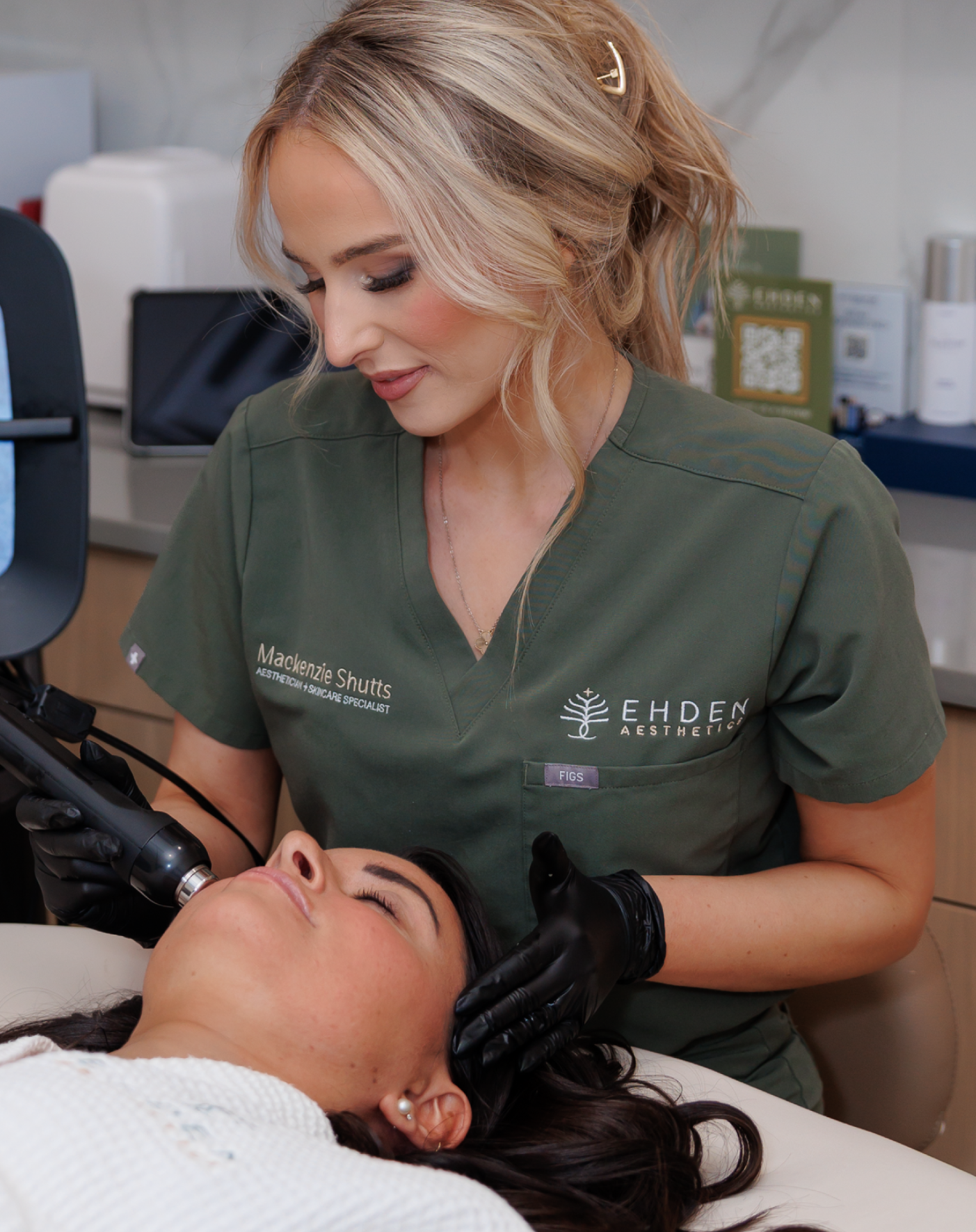 Aesthetician performing a facial treatment on a woman in a spa or clinic setting.