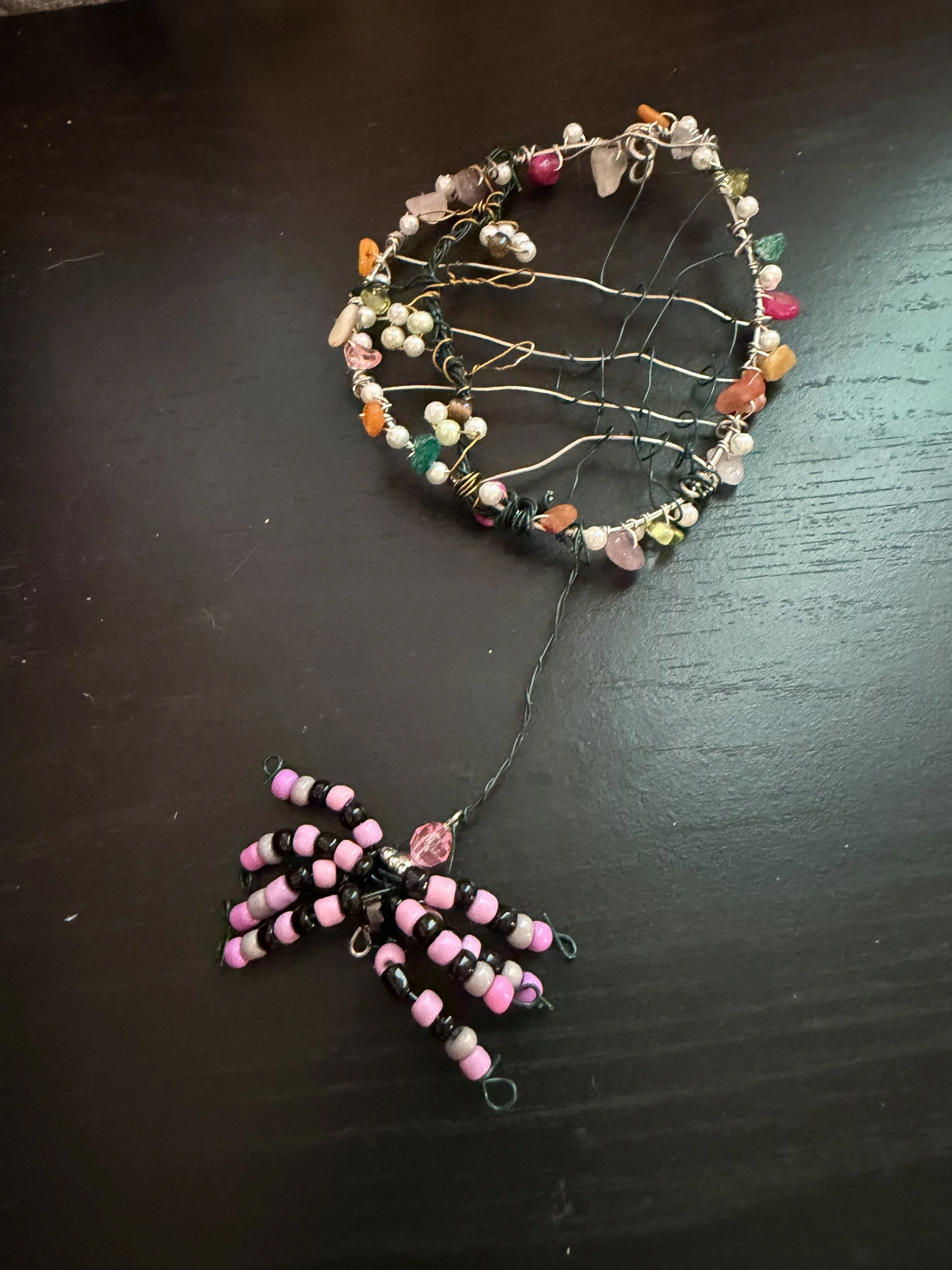 Pink and black spider with web