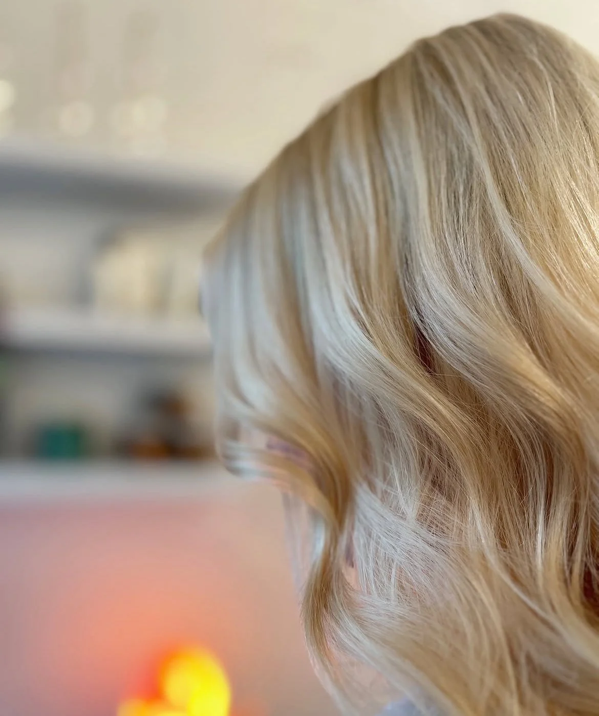Close-up of a woman's blonde, wavy hair viewed from the side