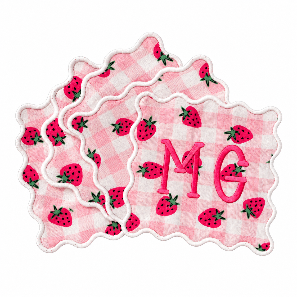 Four pink gingham cocktail napkins with strawberry motifs, scalloped white edges, and a pink MG monogram.