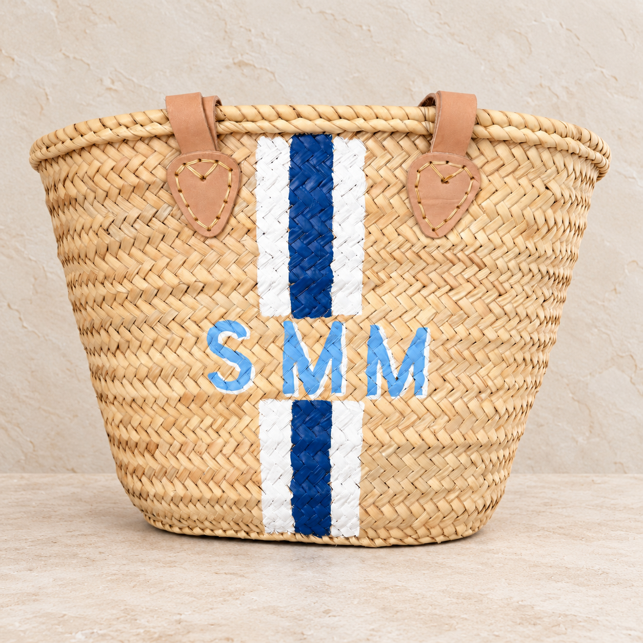 - Personalized woven straw tote hand-painted with blue-and-white stripes and initials by Meg&Co