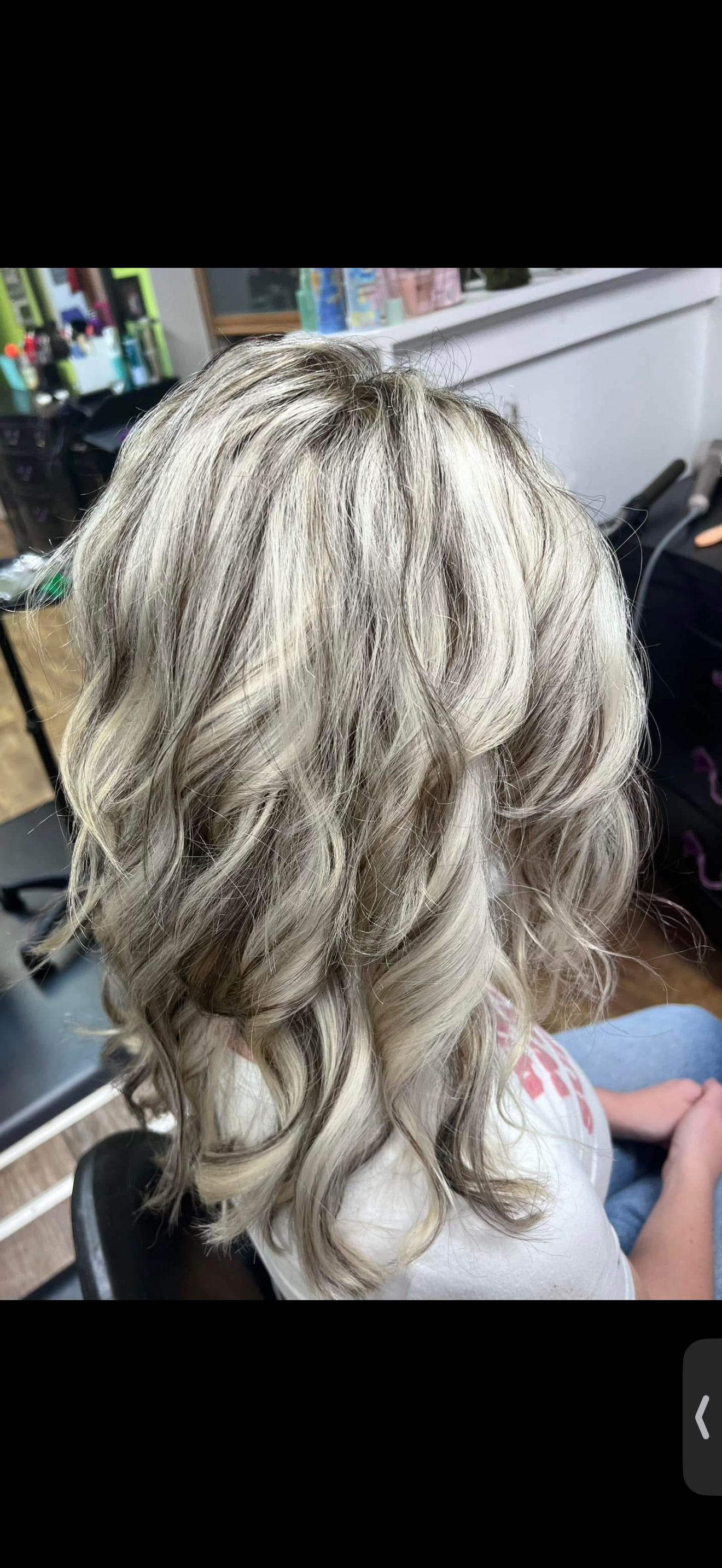 Blonde, curly hair styled in loose waves.