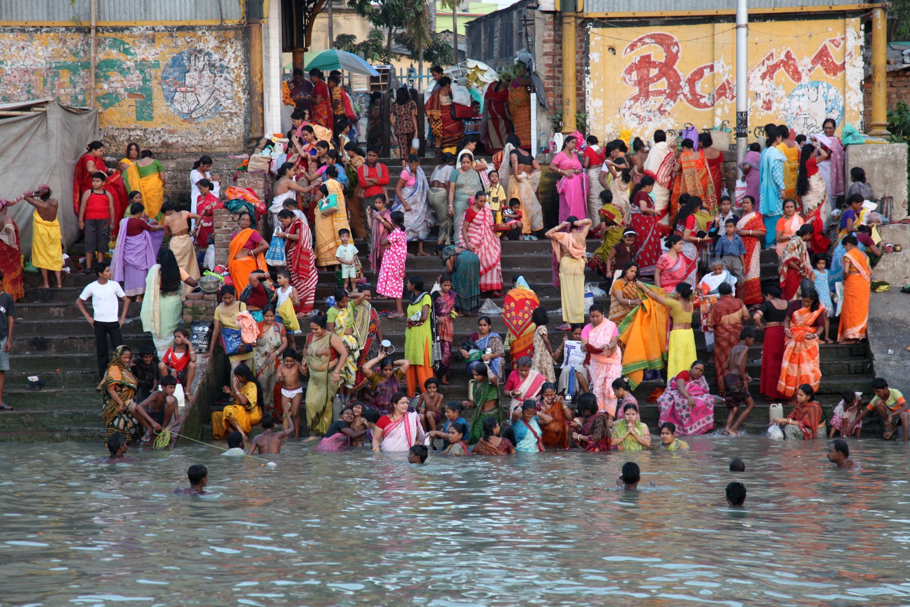Hundreds of people gather at a riverside ghat on the Hooghly River in Kolkata, West Bengal, India. Families bathe, pray and meet along the steps in a scene that reflects the river’s enduring social and religious importance in everyday life.