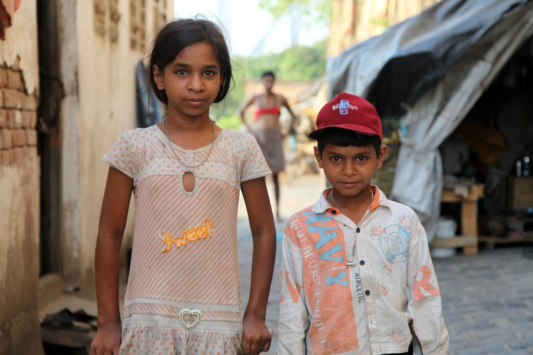Two children stand in a narrow lane of a neighbourhood along the Hooghly River in Kolkata, West Bengal, India. The portrait is part of a documentary series exploring everyday life in communities along the city’s historic waterfront.