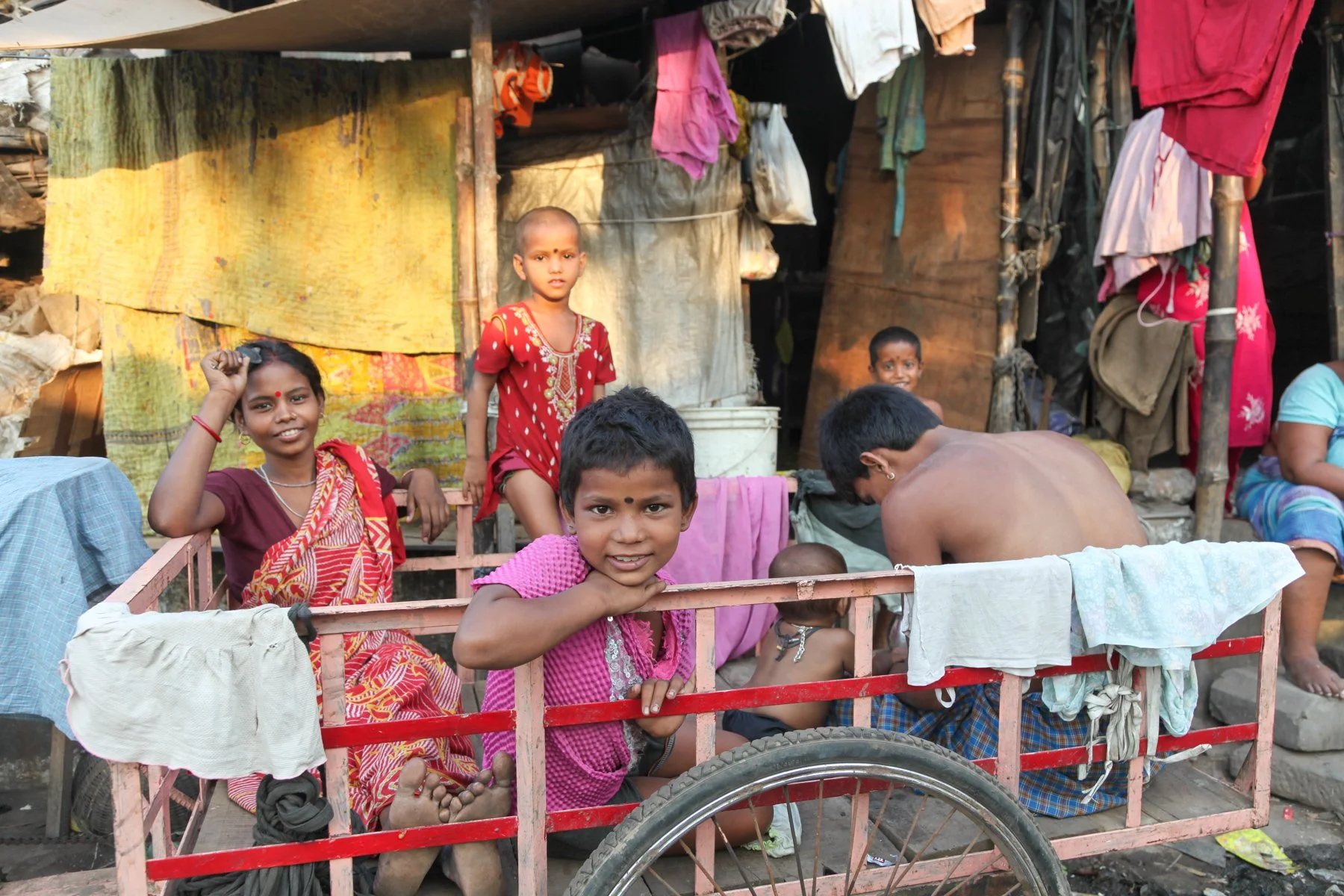 A family gathers outside their home in a neighbourhood along the Hooghly River in Kolkata, West Bengal, India. The image documents everyday life in one of the communities lining the city’s historic waterfront.