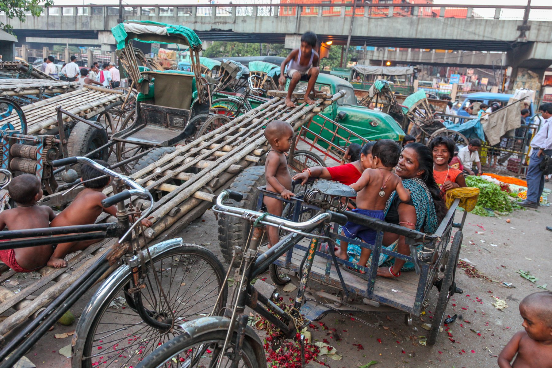 Women and children spend time together among parked cycle rickshaws in a neighbourhood near the Hooghly River in Kolkata, West Bengal, India. Cycle rickshaws remain an important part of daily life and local transport in many parts of the city. April 
