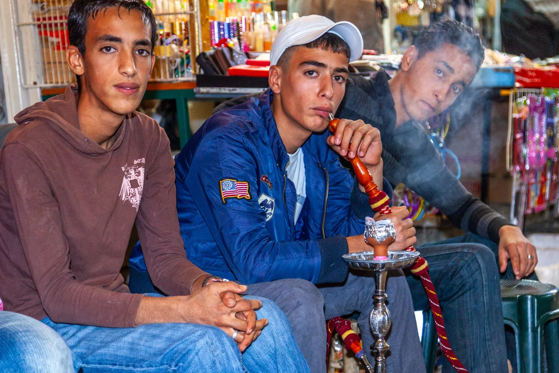 Three young men sitting outside a café smoking a water pipe in Jerusalem’s Old City.