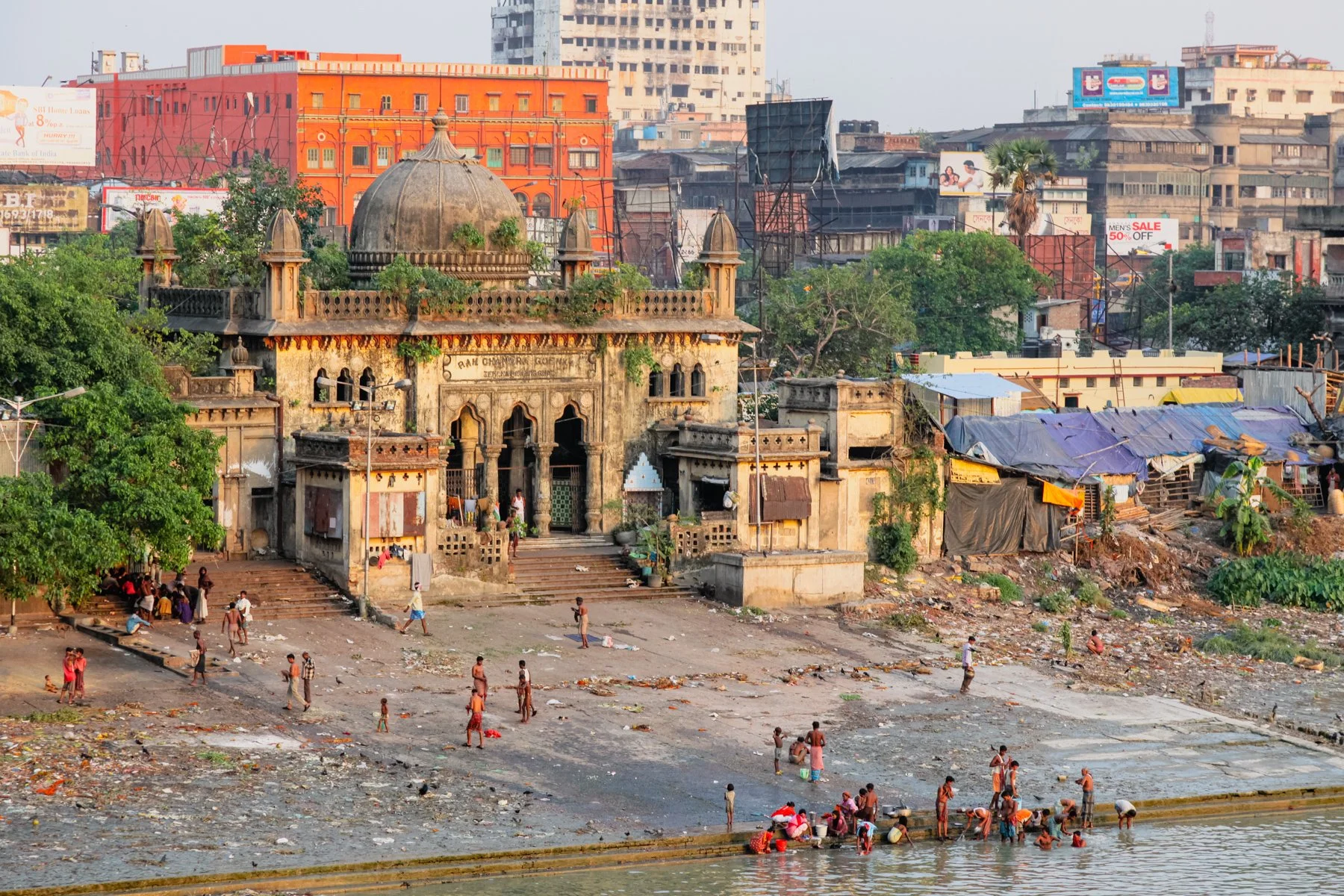 People gather, bathe and go about their daily routines along the Hooghly River in Kolkata, West Bengal, India. Historic riverside architecture and informal settlements illustrate the close relationship between the city and its river. April 2009.