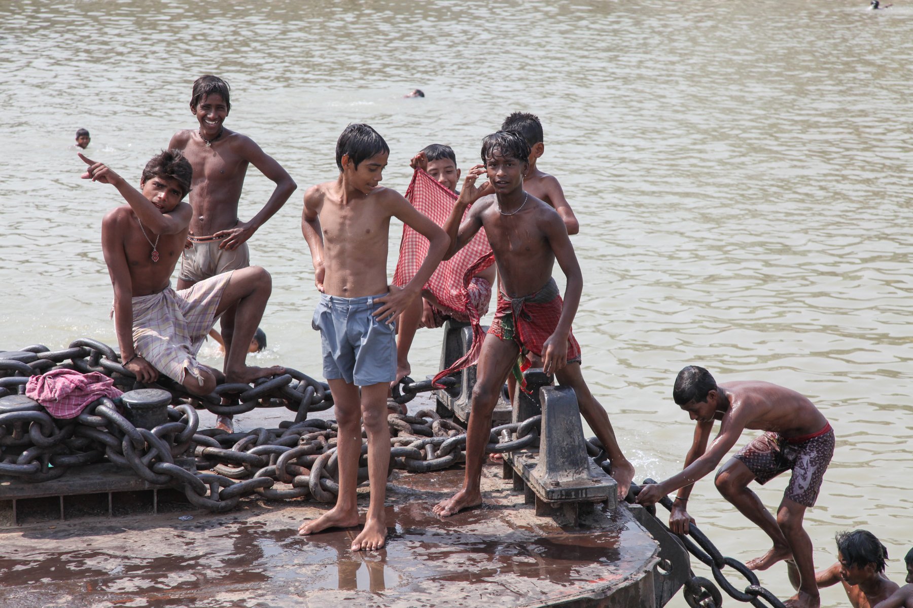 A group of boys gather on the bow of a moored ferry before swimming in the Hooghly River in Kolkata, West Bengal, India. During the hot season, ferries and riverbanks become popular places for children to play, swim and spend time together. April 200