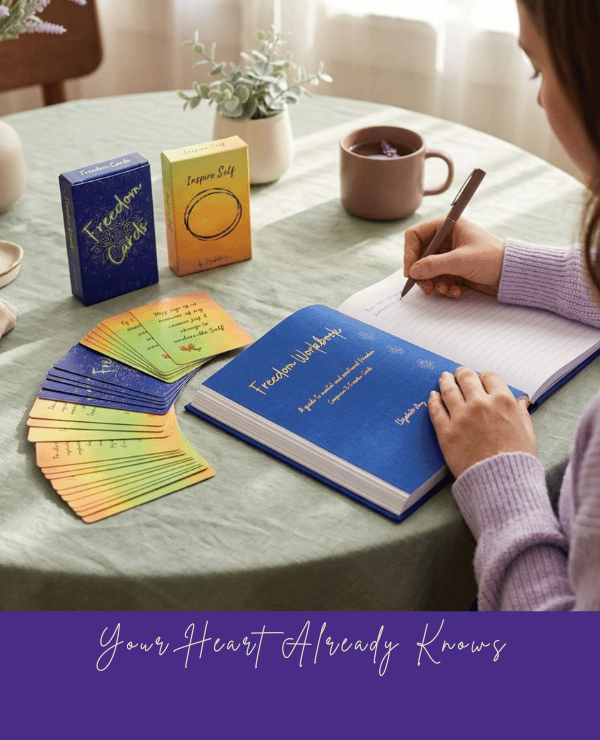 Person reading the Freedom Journal alongside affirmation cards, inspirational books, and a warm cup of coffee, creating a peaceful space for reflection, gratitude, and personal growth.