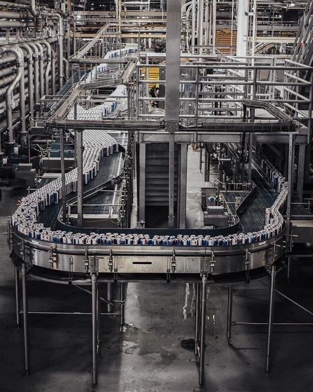 A conveyor belt in a factory transporting cans.