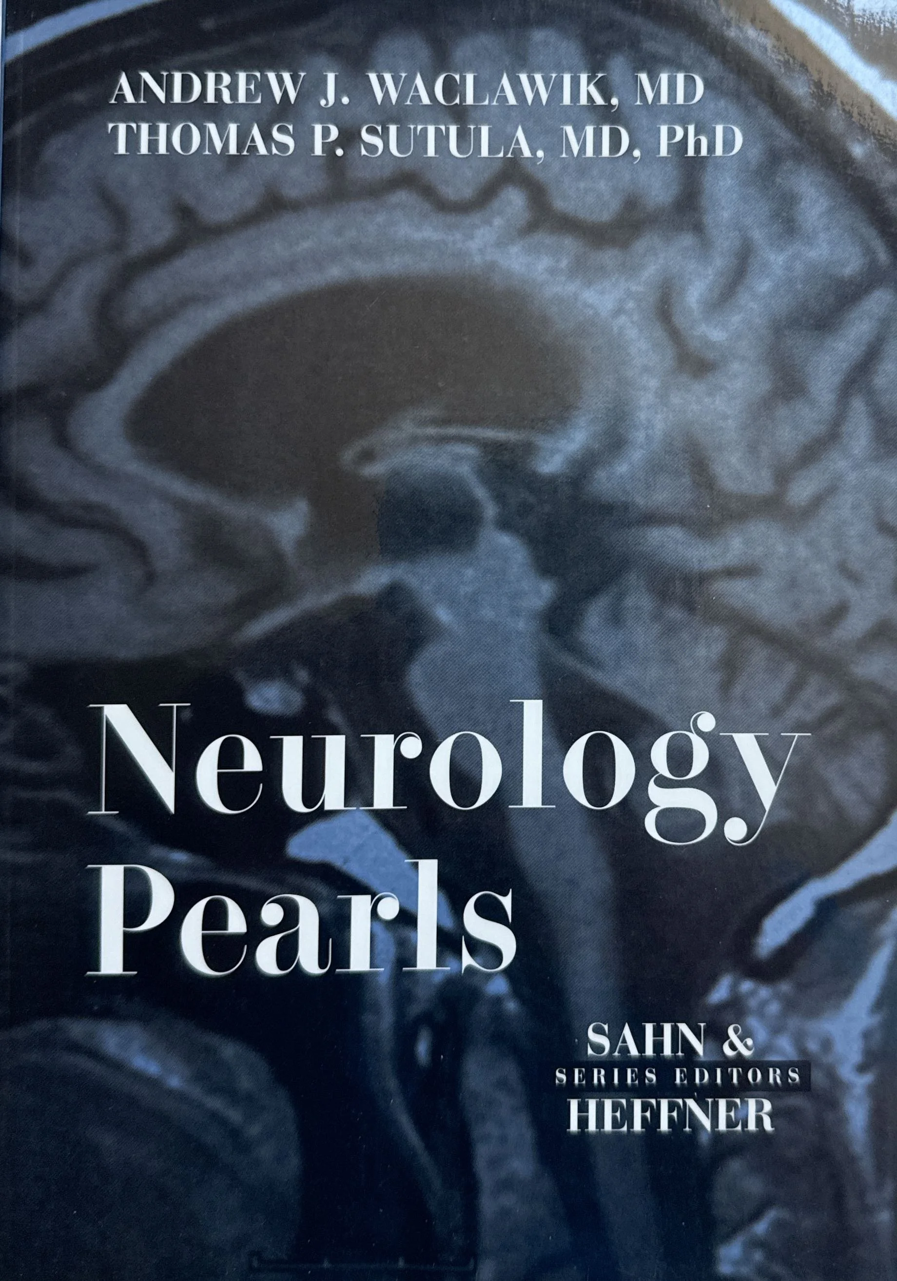 Close-up of a book cover titled 'Neurolegy Pearls' by authors Andrew J. Waclawik, MD, Thomas P. Sutula, MD, PhD, with additional text indicating its publication by HEFFNER, Sahn & Series Editors. The background features a grayscale image of a brain MRI scan.