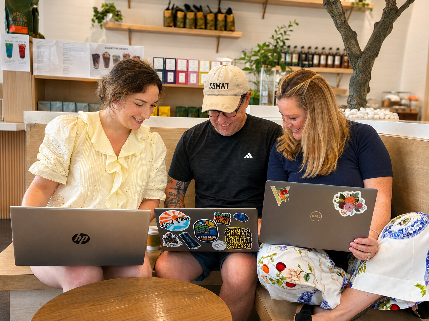 the 3 founders at a coffee shop working on their laptops