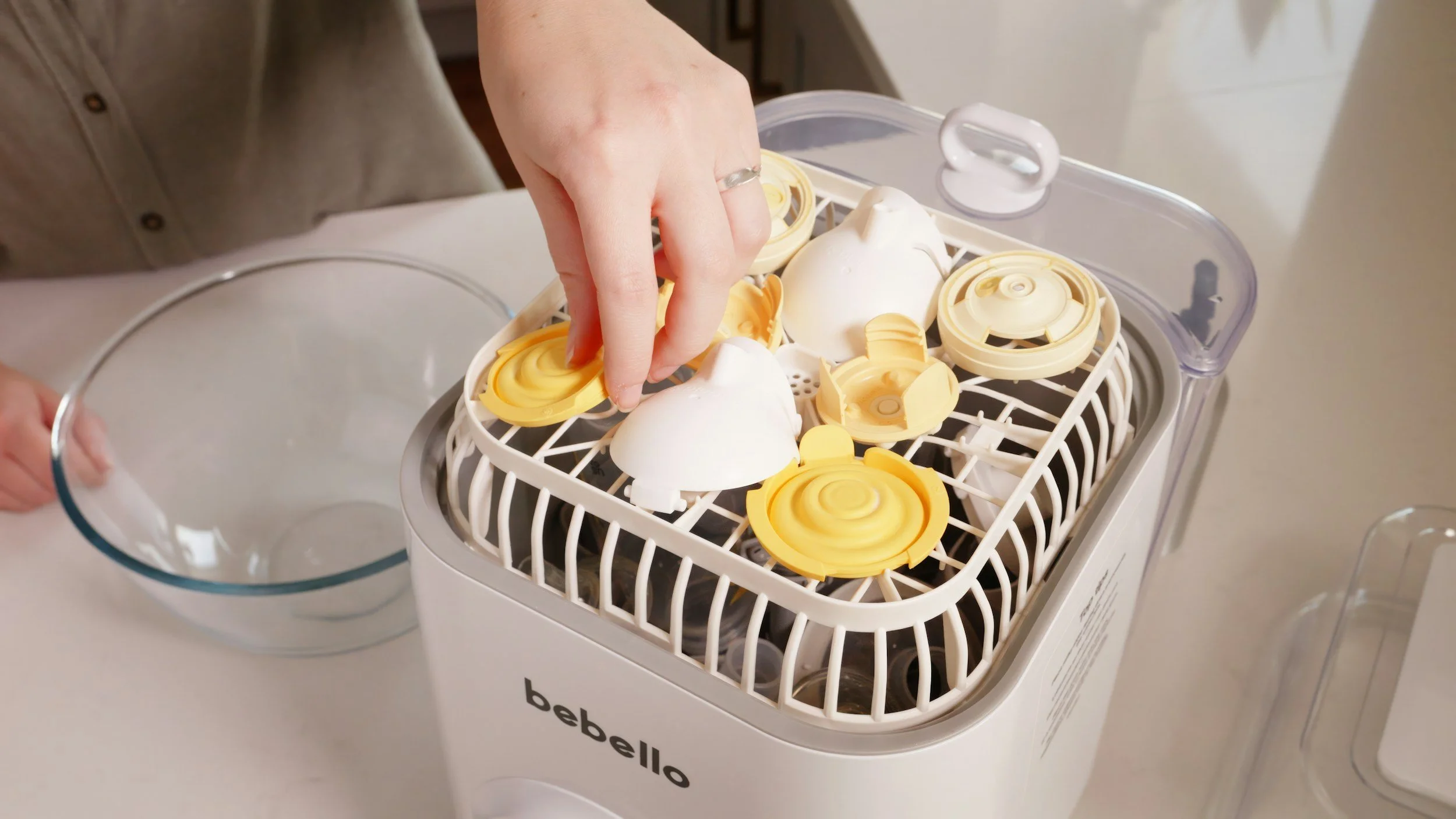 Person removing bottle and bread pump parts from a bottle washer.