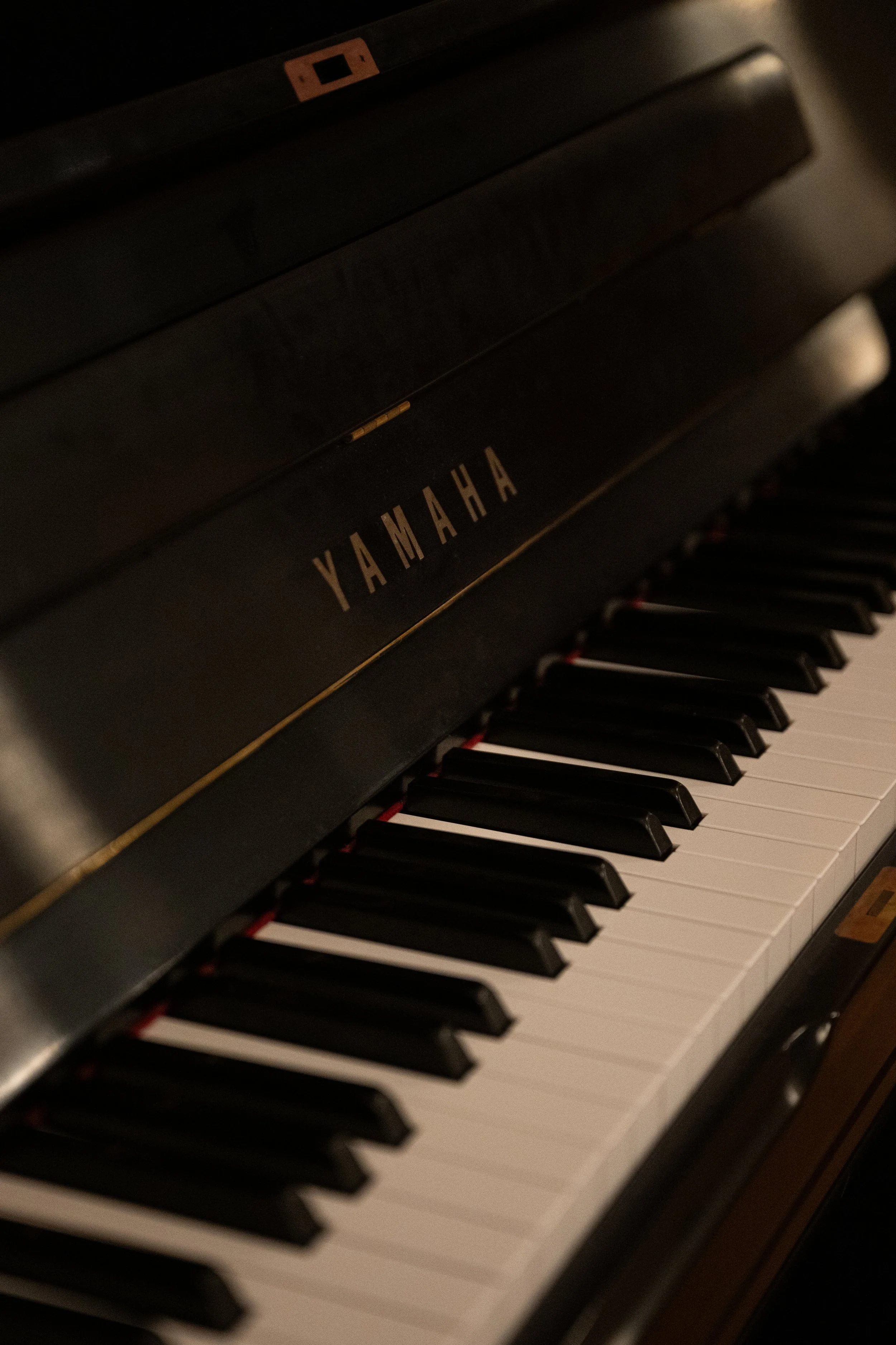 Close-up of a black Yamaha digital piano keyboard, showing black and white keys.