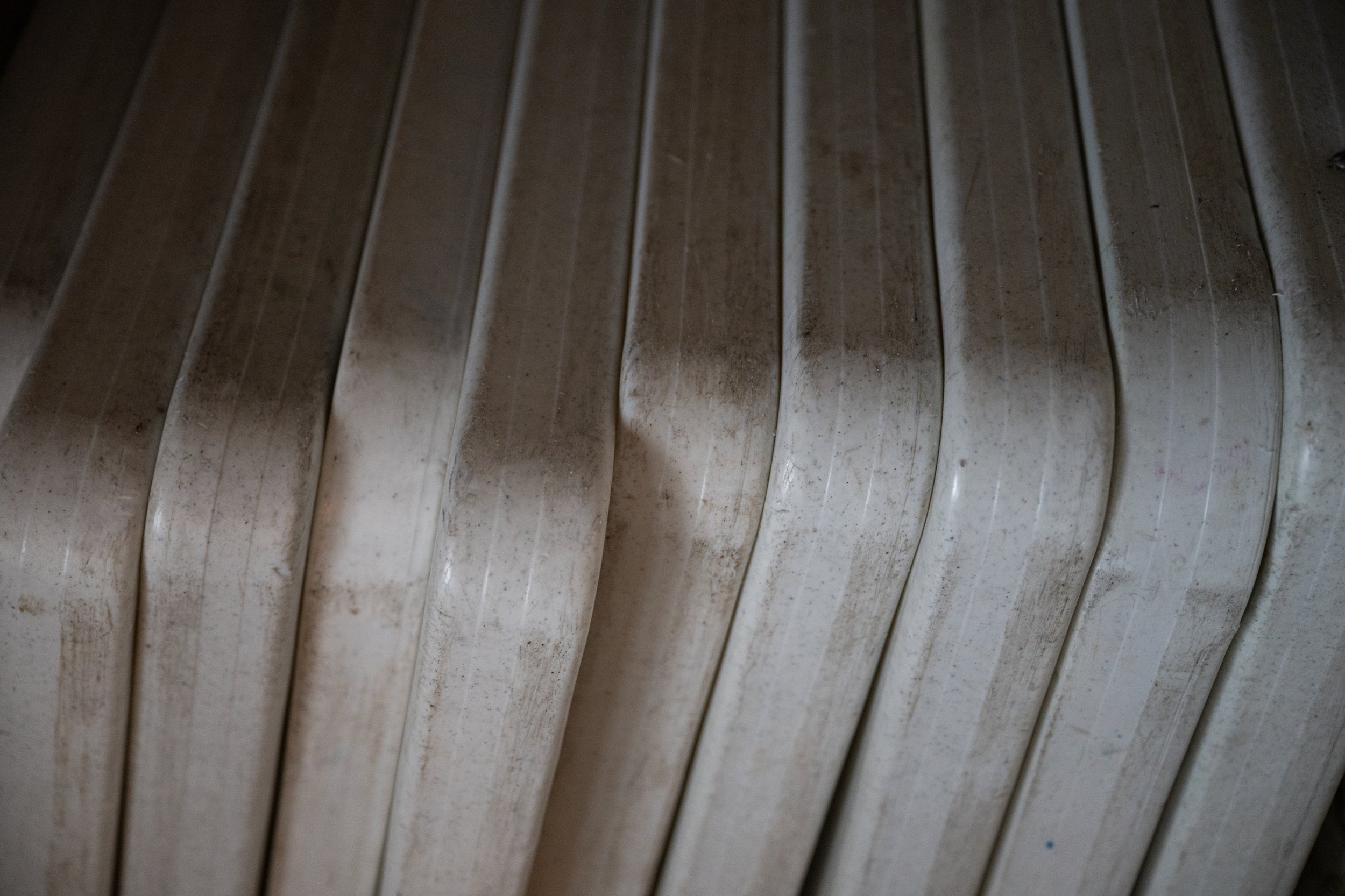 Close-up of metal boat cleats mounted on a wooden dock, showing signs of rust and weathering.