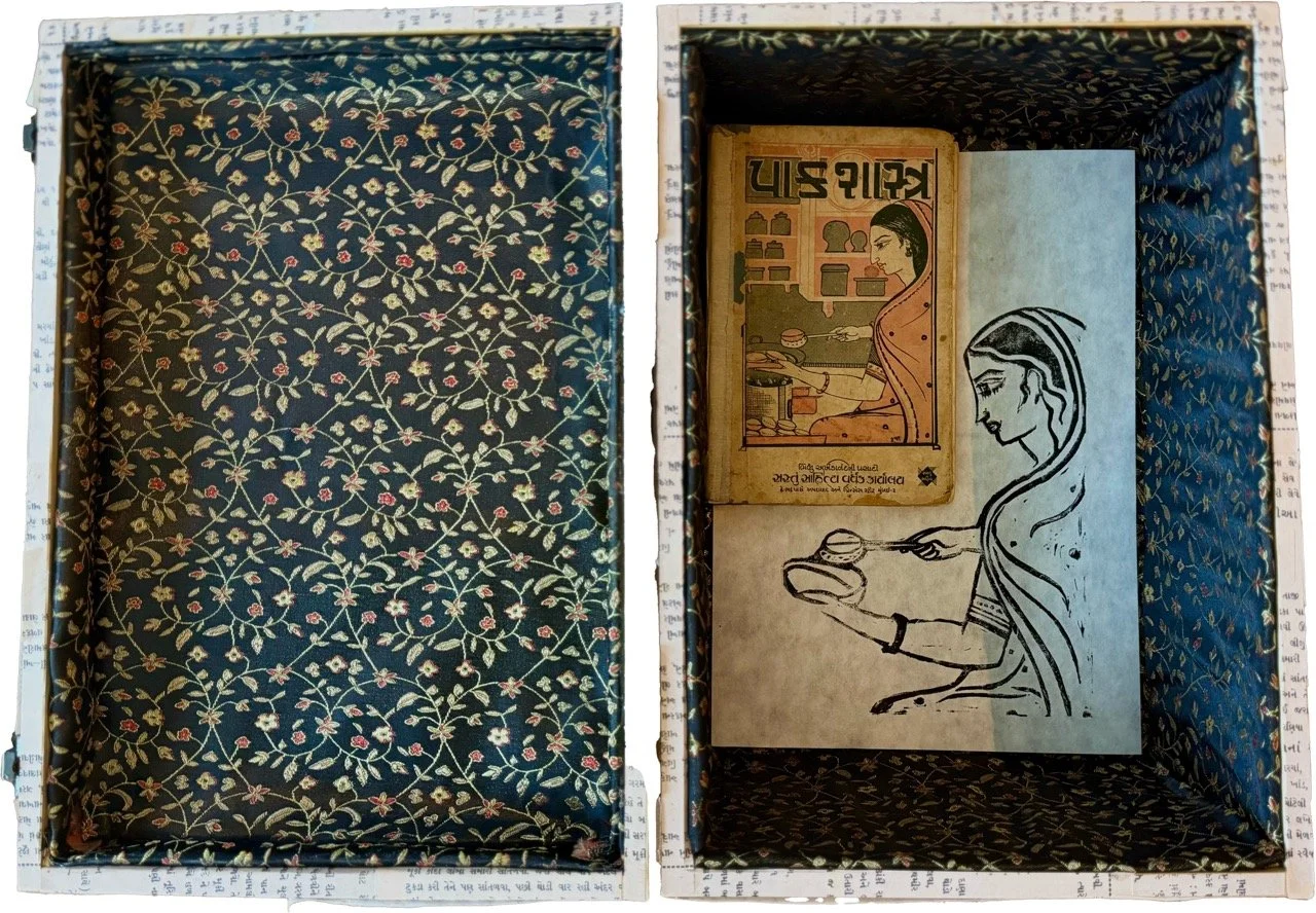(re)Crafting the Self, pictured open. The box is lined with Indian brocade silk, pictured here containing Paak Shastra (the source material for (r)CS) and an printing of a blockprint style stamp that is an interpretation of the cover of Paak Shastra.