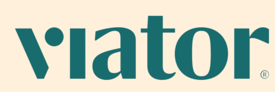 The image shows a logo with the word 'viator' in large, teal-colored letters on a beige background.