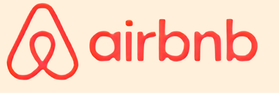 Airbnb logo featuring a stylized red heart-shaped symbol and the word 'airbnb' in lowercase red letters on a light background.