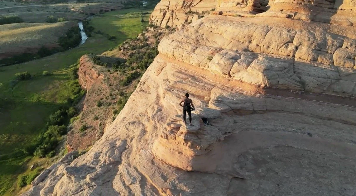 Yoga teacher Charla Chatman standing at a mountain overlook at golden hour, representing the transformative journey of The Return 6-week somatic yoga program for healing after grief, depression, and trauma