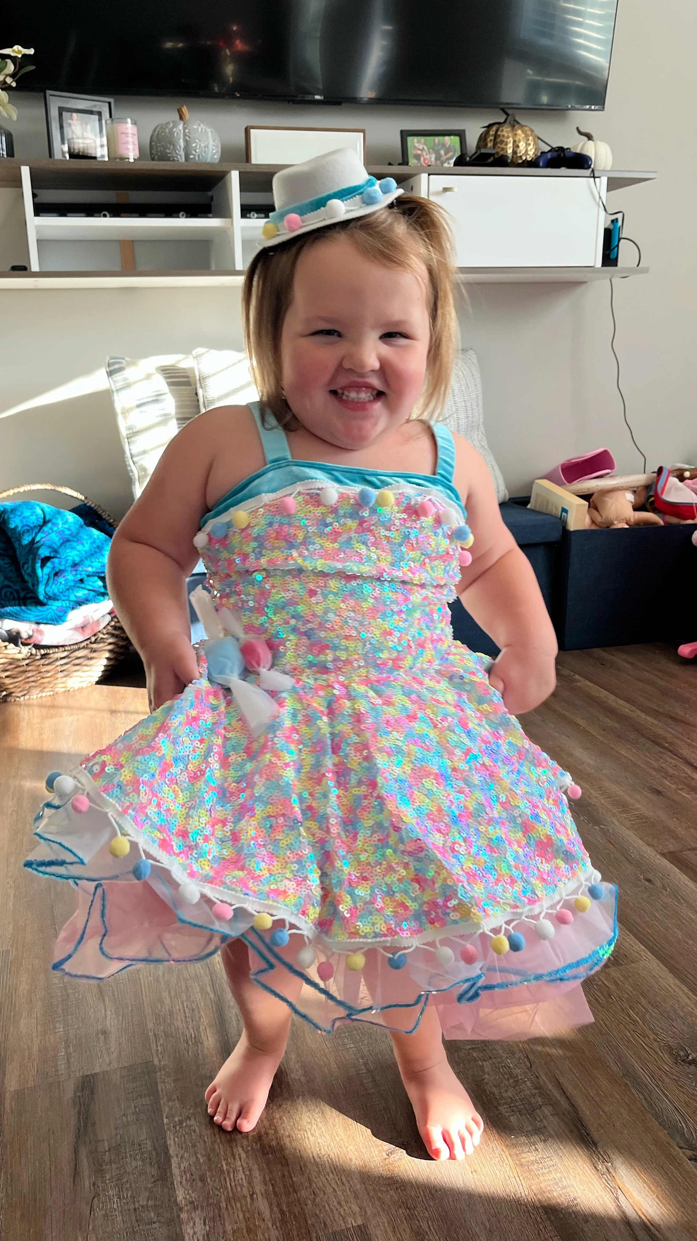 Bella Grace smiling in a white dance costume and top hat, reflecting the joy, confidence, and childlike spirit that continue to inspire the Believe Like Bella ministry.