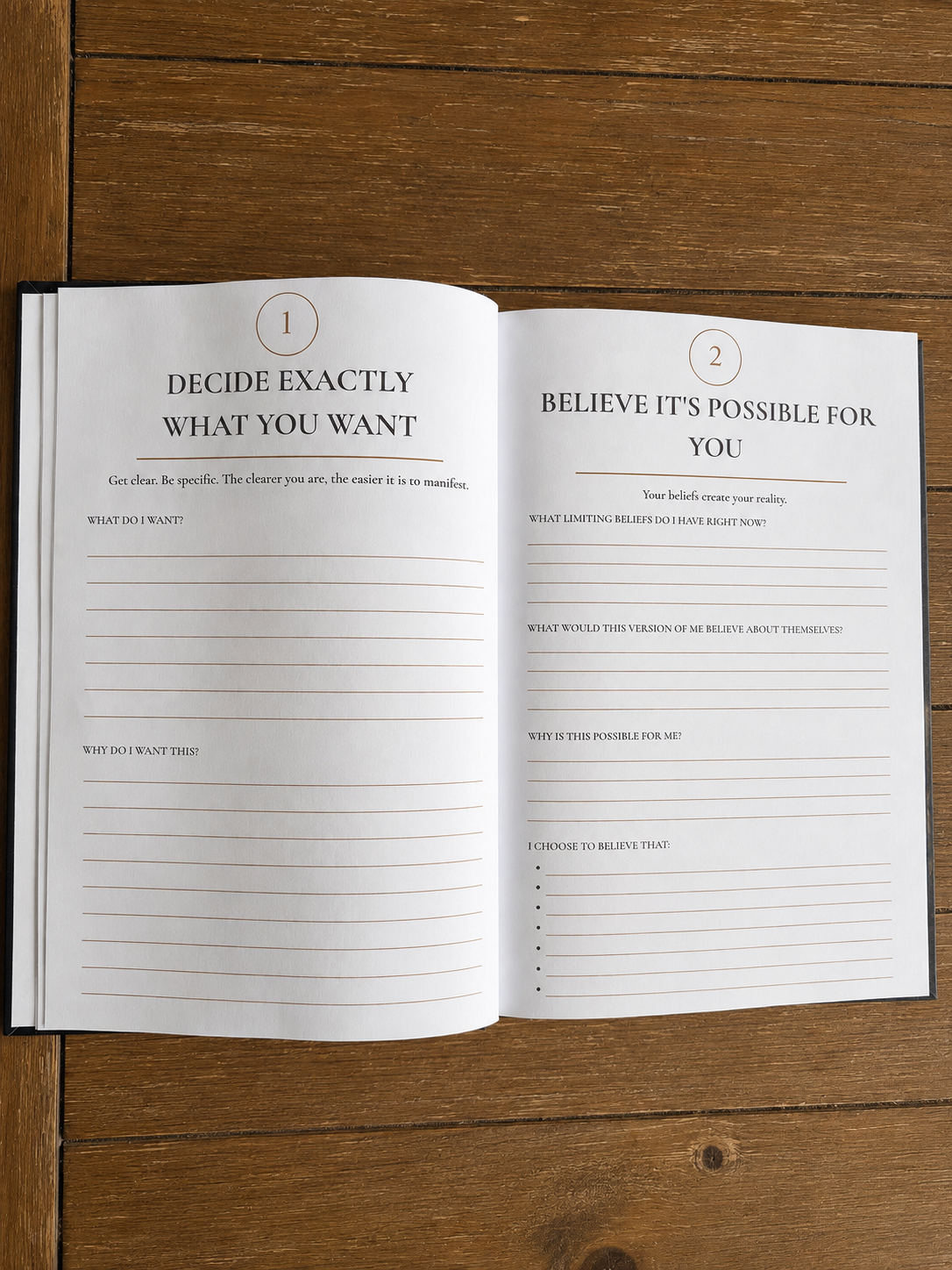 Open journal with two pages; left page titled 'Decide exactly what you want,' right page titled 'Believe it's possible for you'; both pages contain prompts for writing beliefs and goals, on a wooden surface.