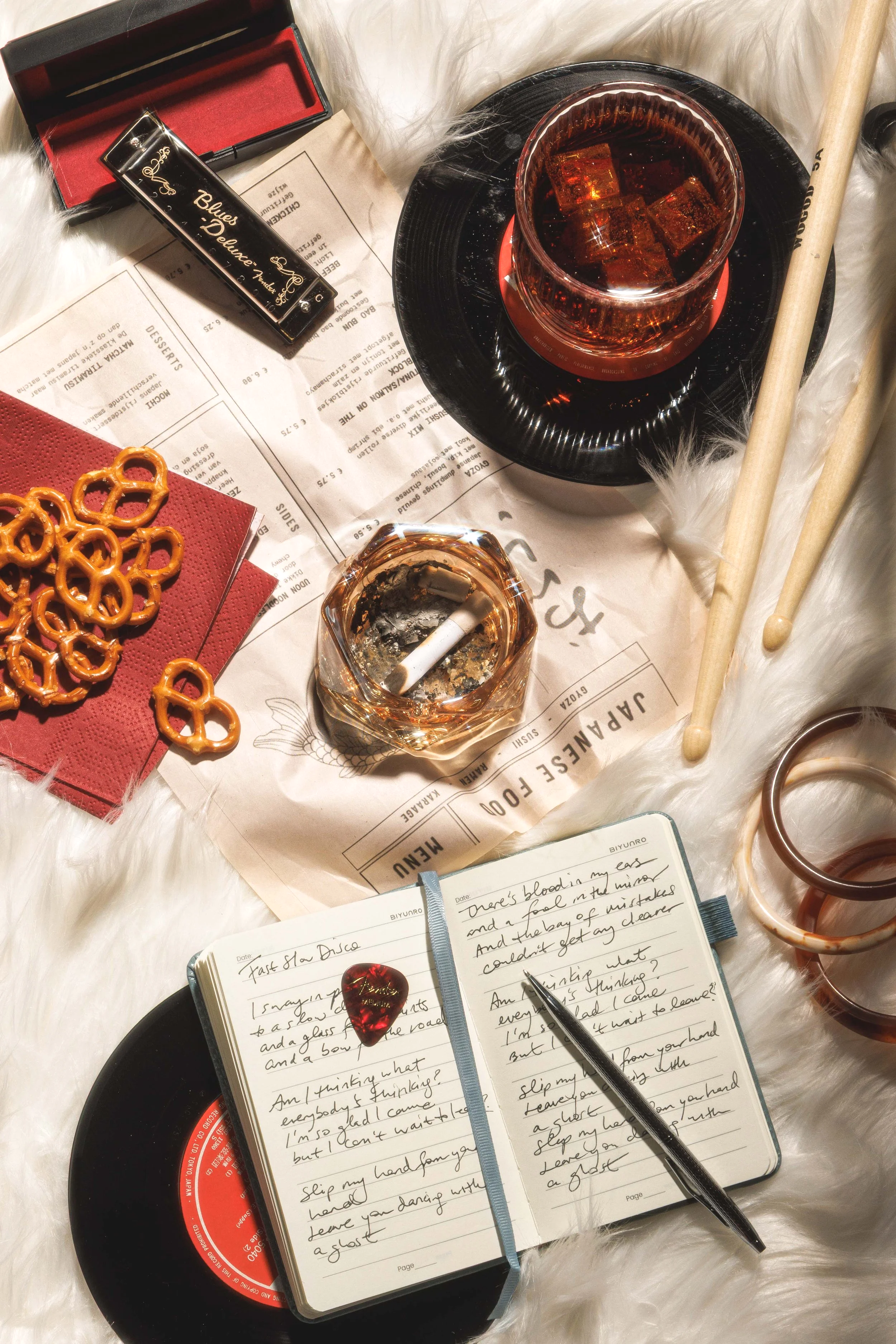Editorial lifestyle photo of musical instruments, food and drink on a rug, by Amy Carson.