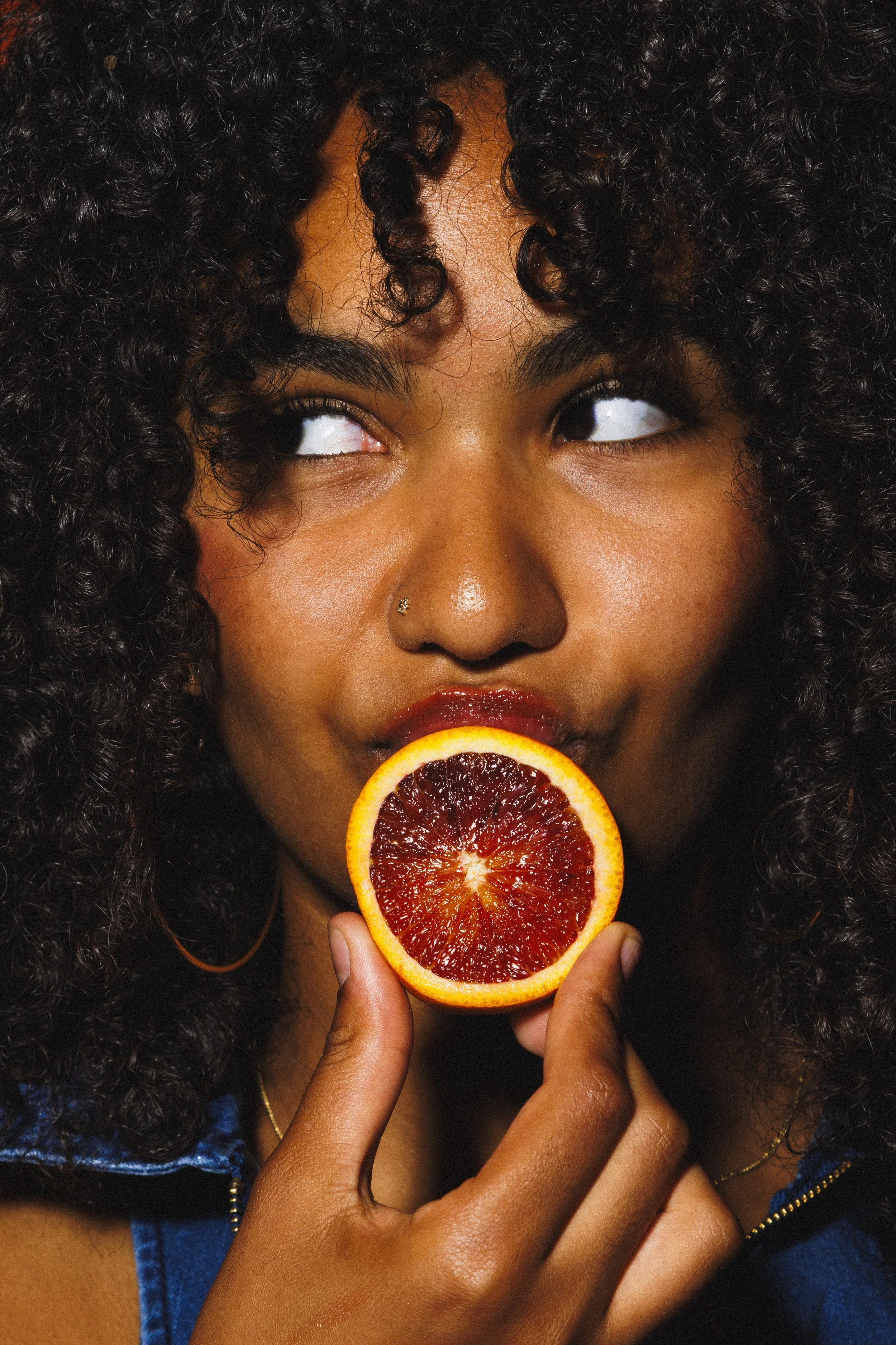 Commercial lifestyle portrait of a woman with an orange for an advertising campaign.