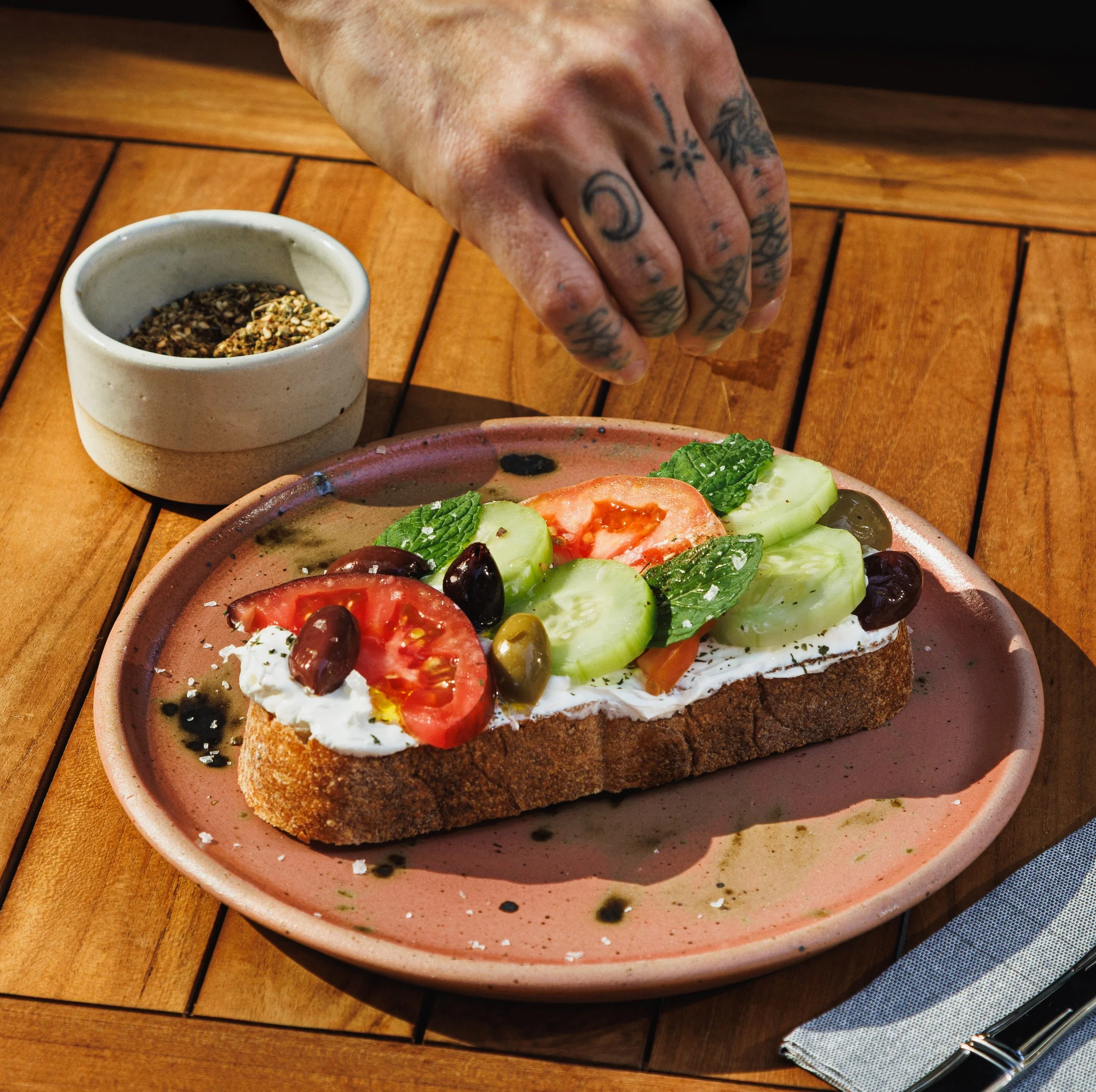 Commercial food photo of a person sprinkling salt on toast in Southern California.