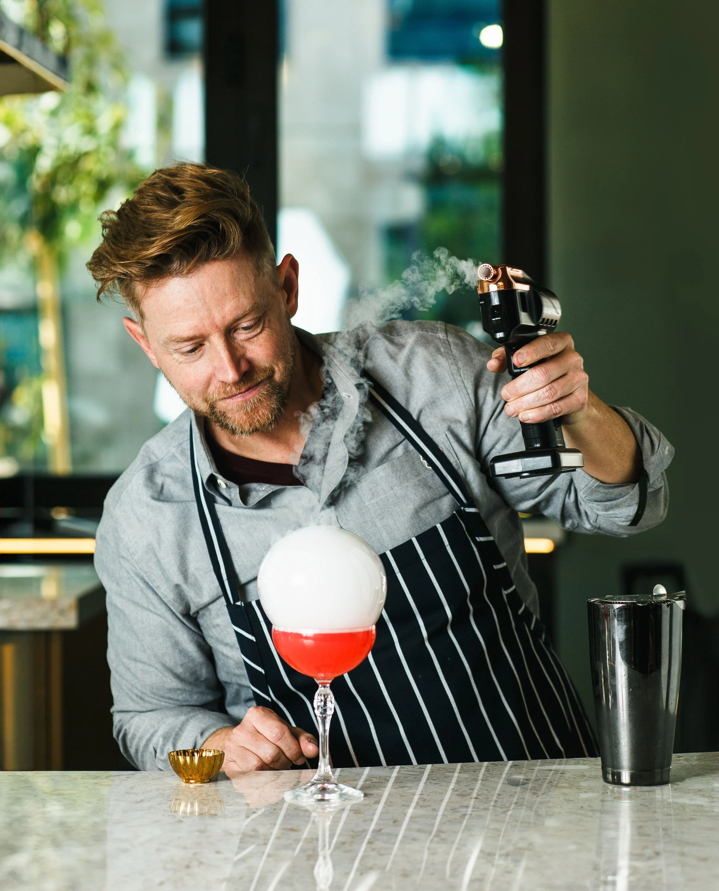 Commercial lifestyle portrait of celebrity chef Richard Blais making a cocktail.