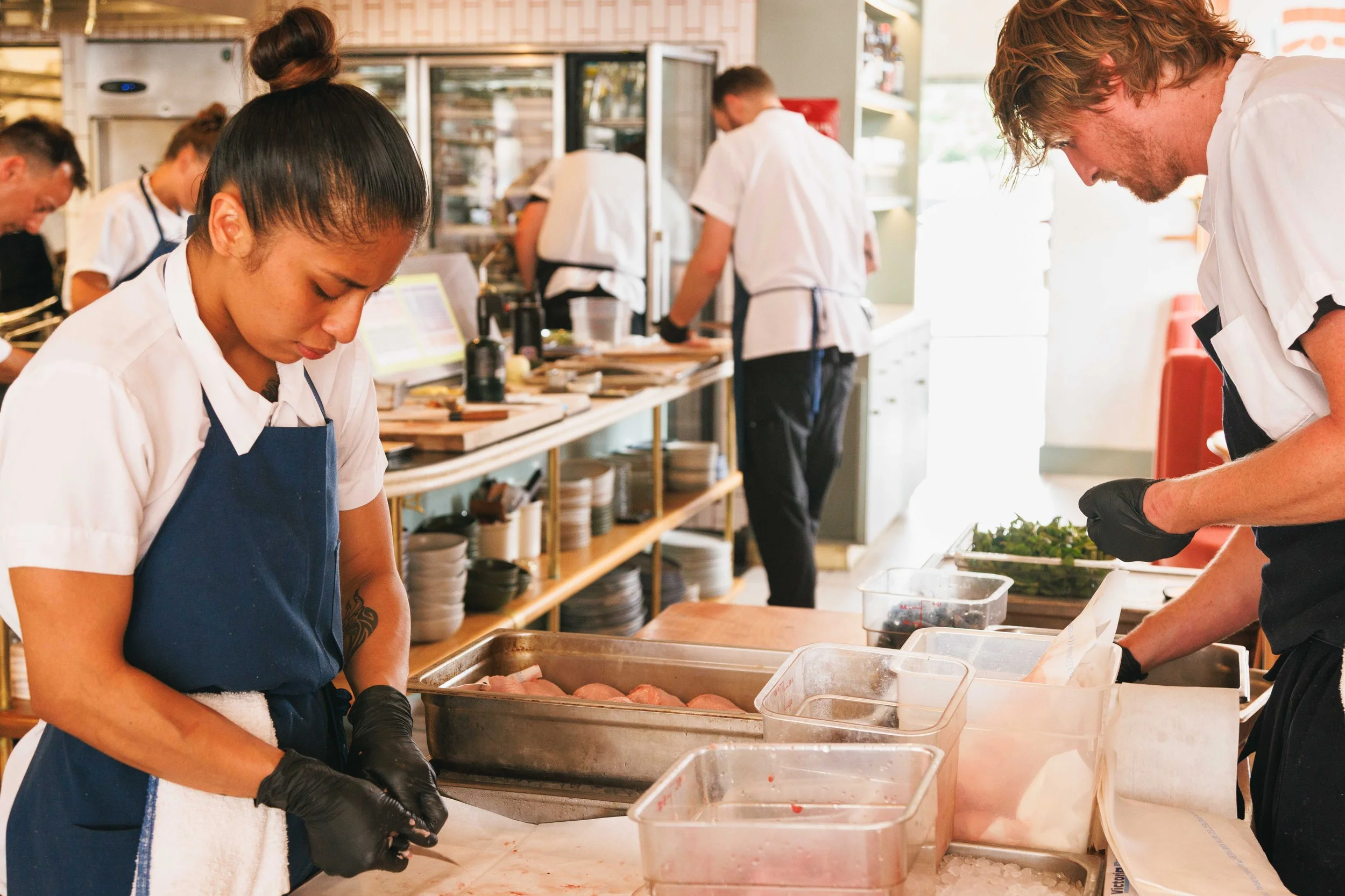 Editorial photo of chefs preparing food in the kitchen of a fine dining restaurant.