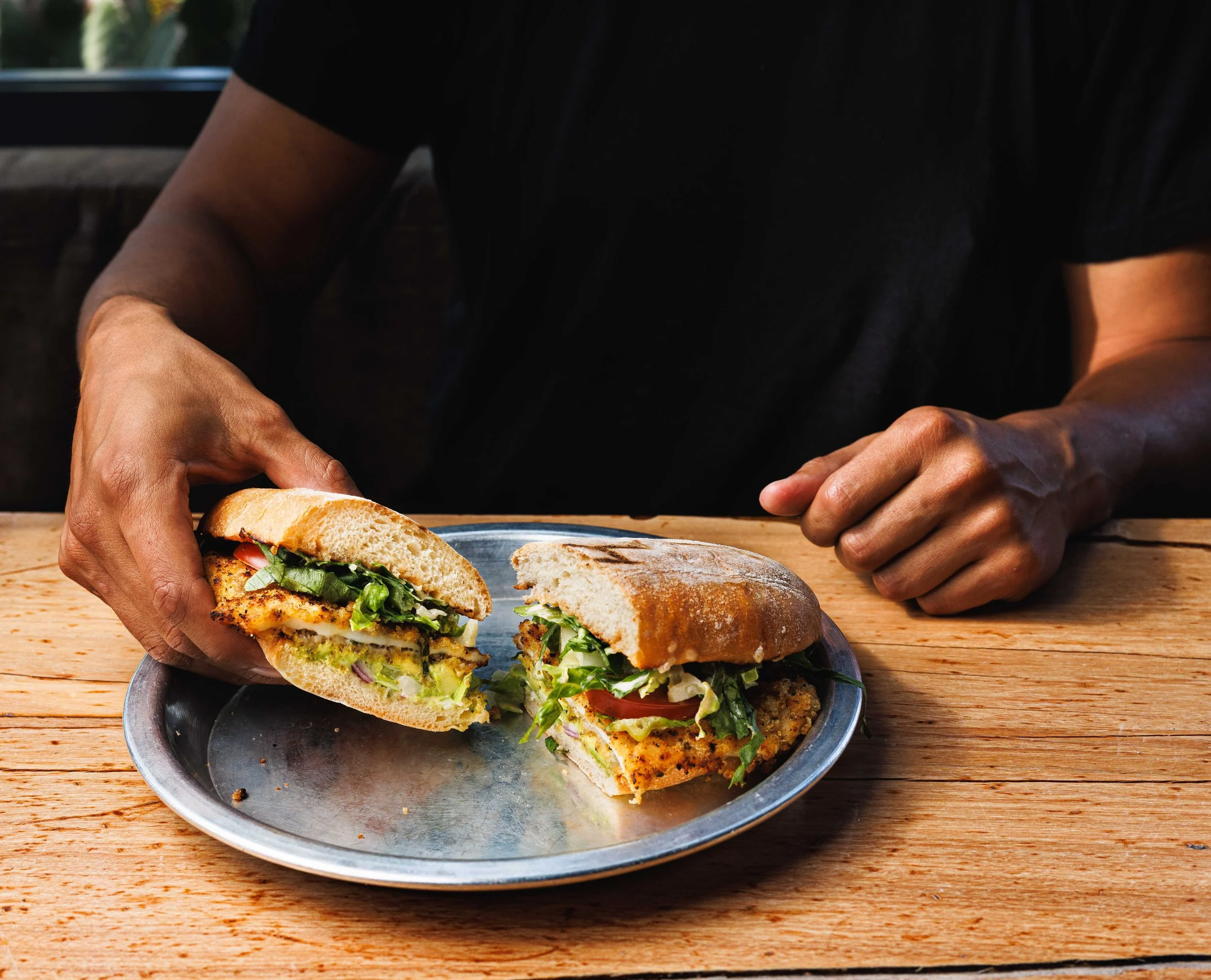 Commercial food photo of a man holding a sandwich at El Pescador restaurant in San Diego, California.