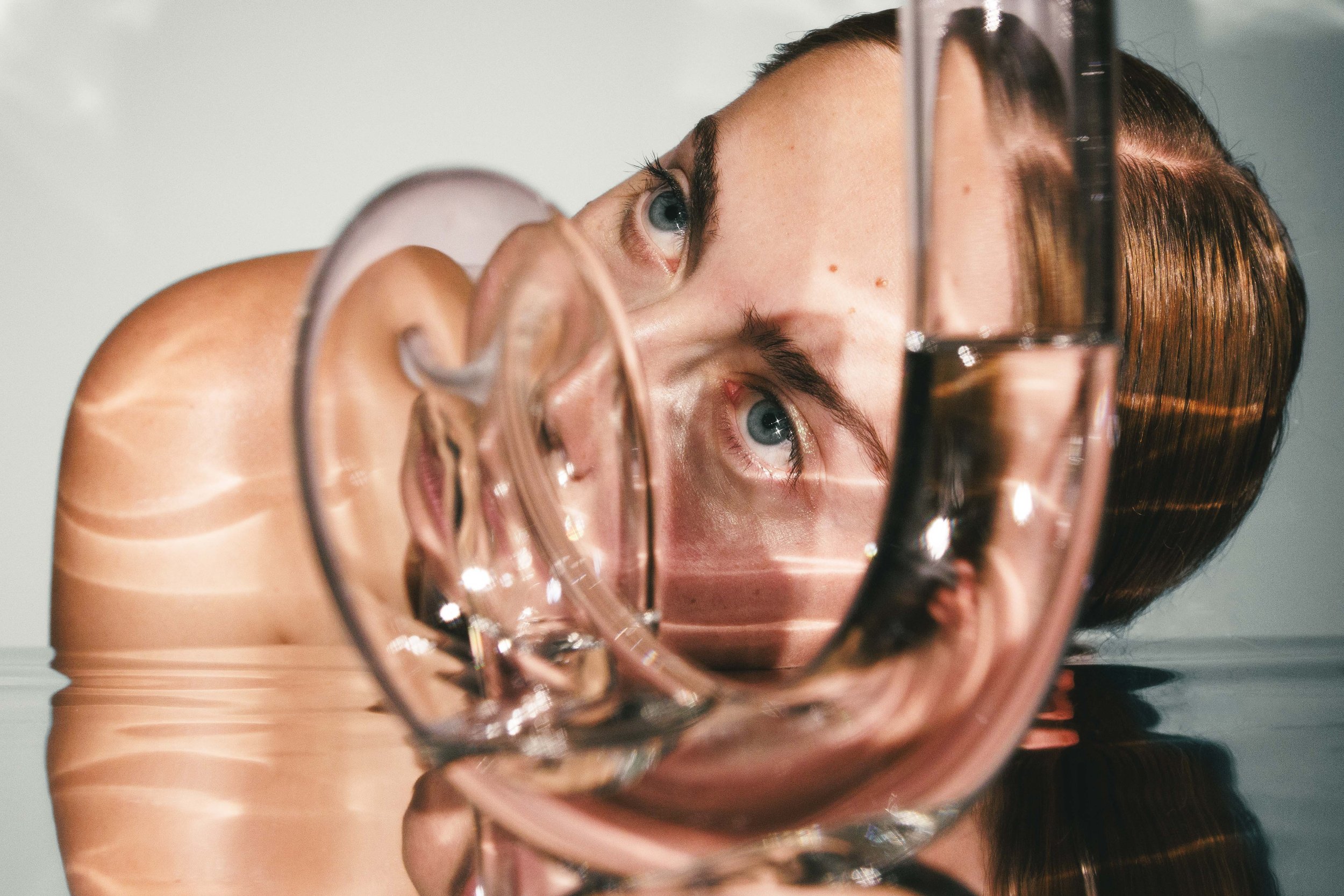 Conceptual beauty photo of a woman looking through glass objects.