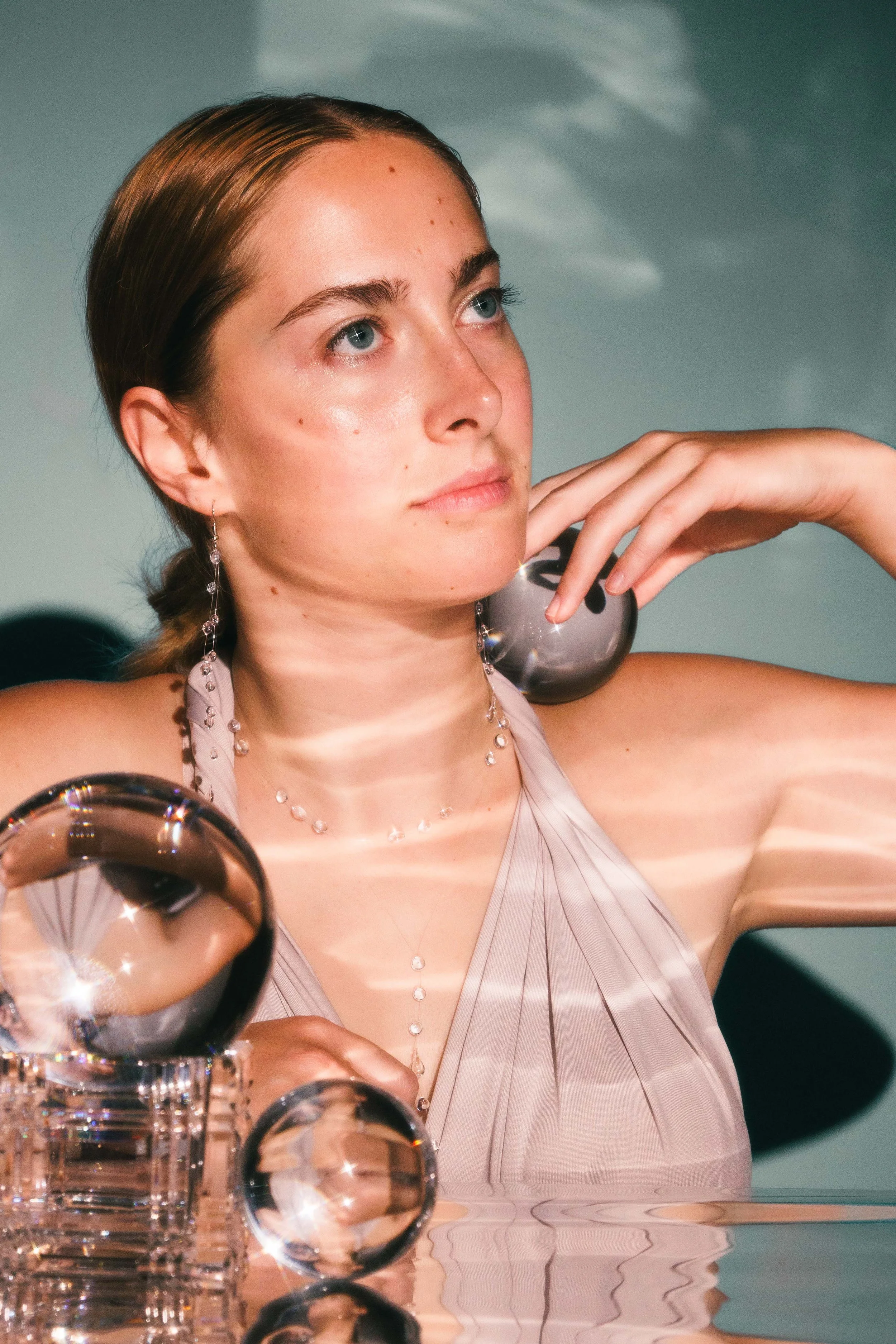 Conceptual editorial photo of a woman posing with crystal balls.