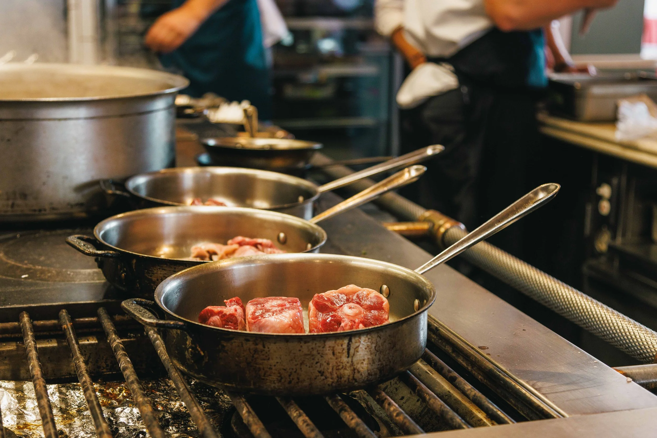 Editorial photo of meat cooking in the commercial kitchen of a Michelin starred restaurant.