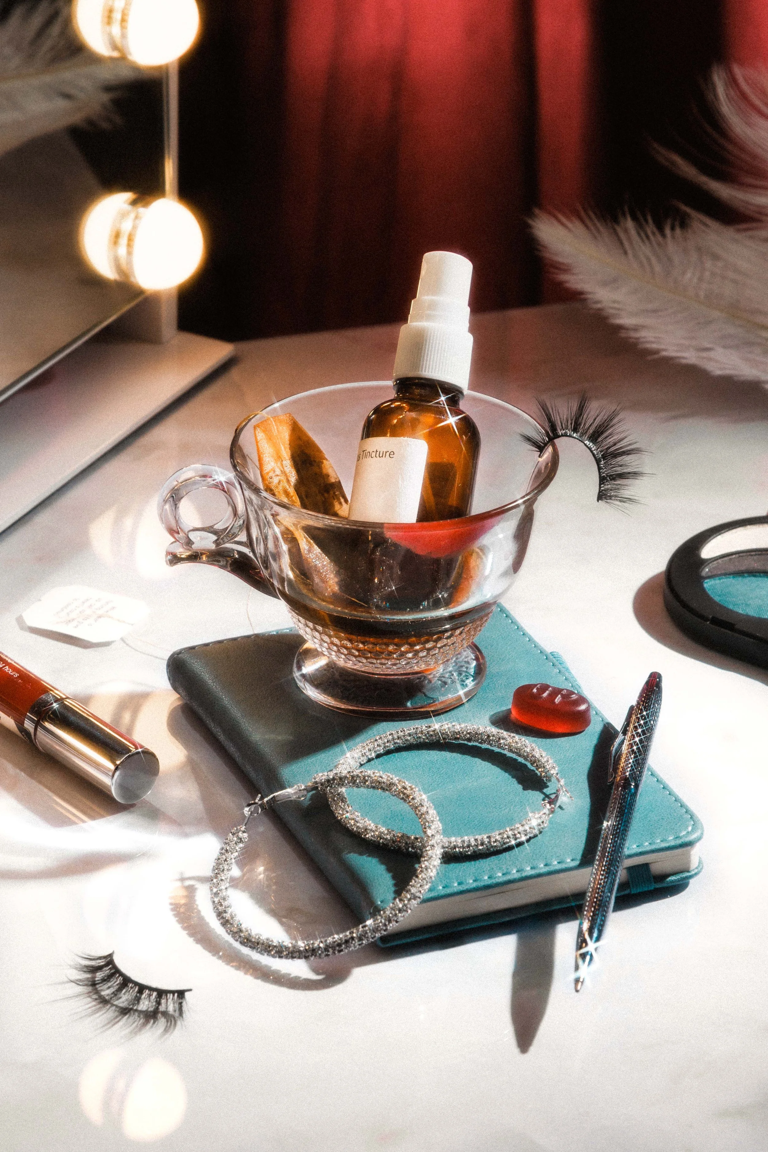 Conceptual still life photo featuring beauty products, tea, and jewelry.