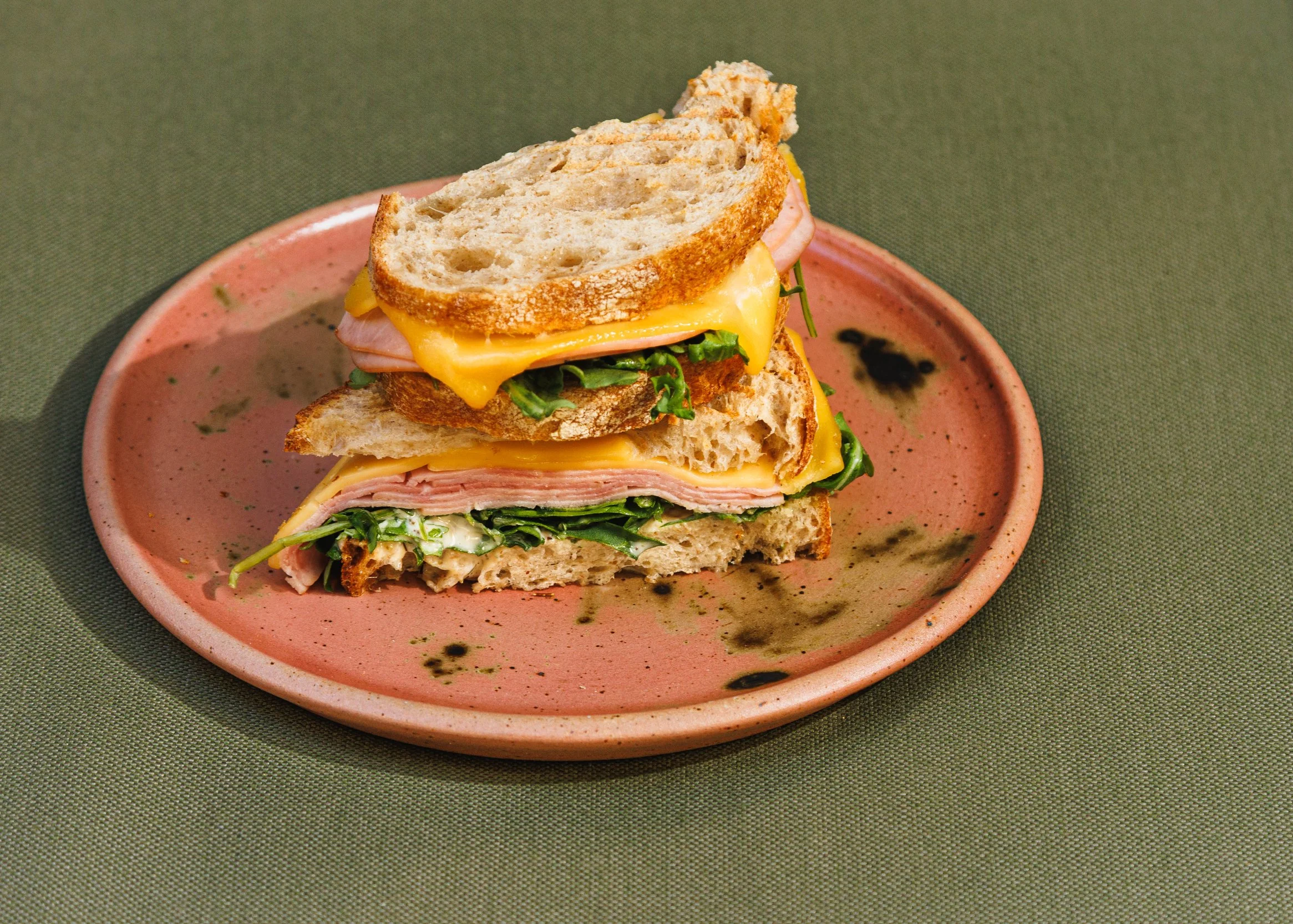 Commercial food photo of a stacked ham and cheese sandwich for a restaurant hospitality campaign.