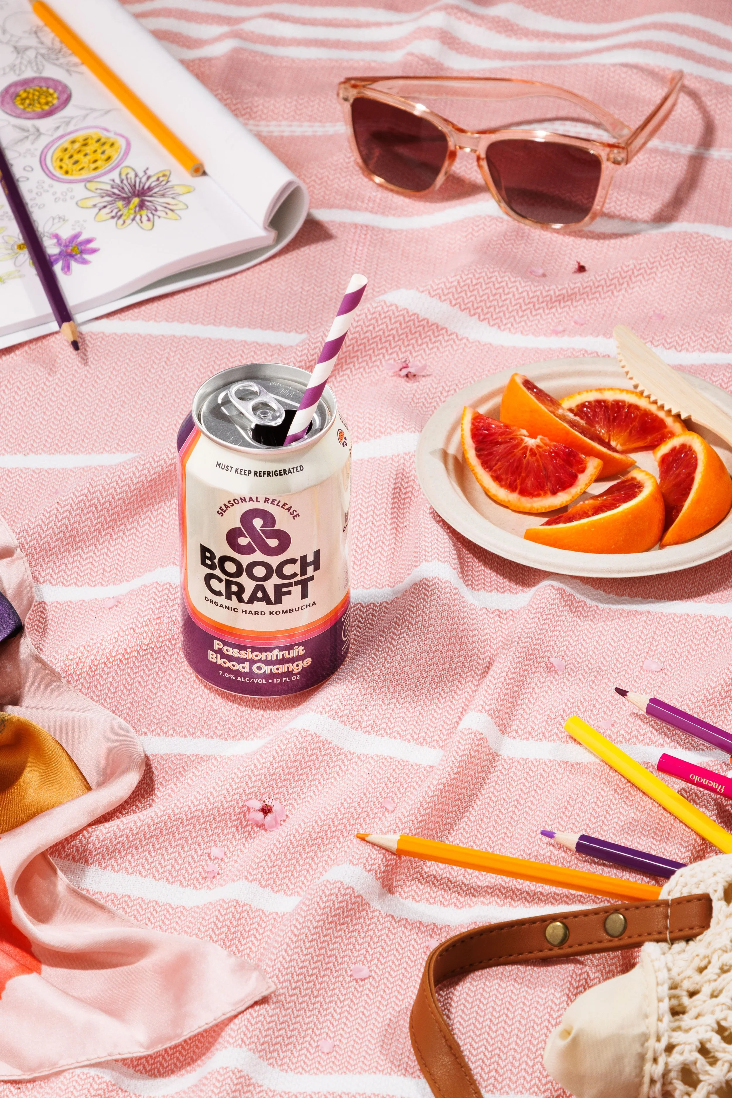 Commercial beverage photo of a can of kombucha with a straw in a picnic scene for a Boochcraft campaign.