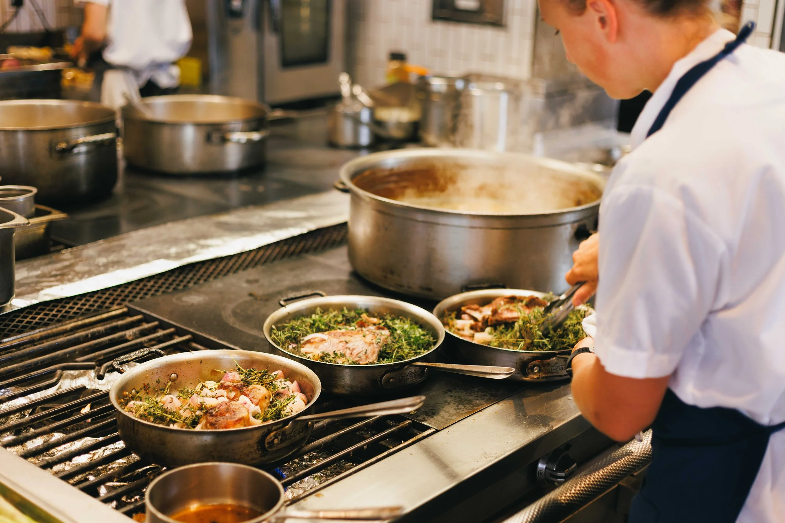Hospitality photo of a chef cooking in a commercial restaurant kitchen.