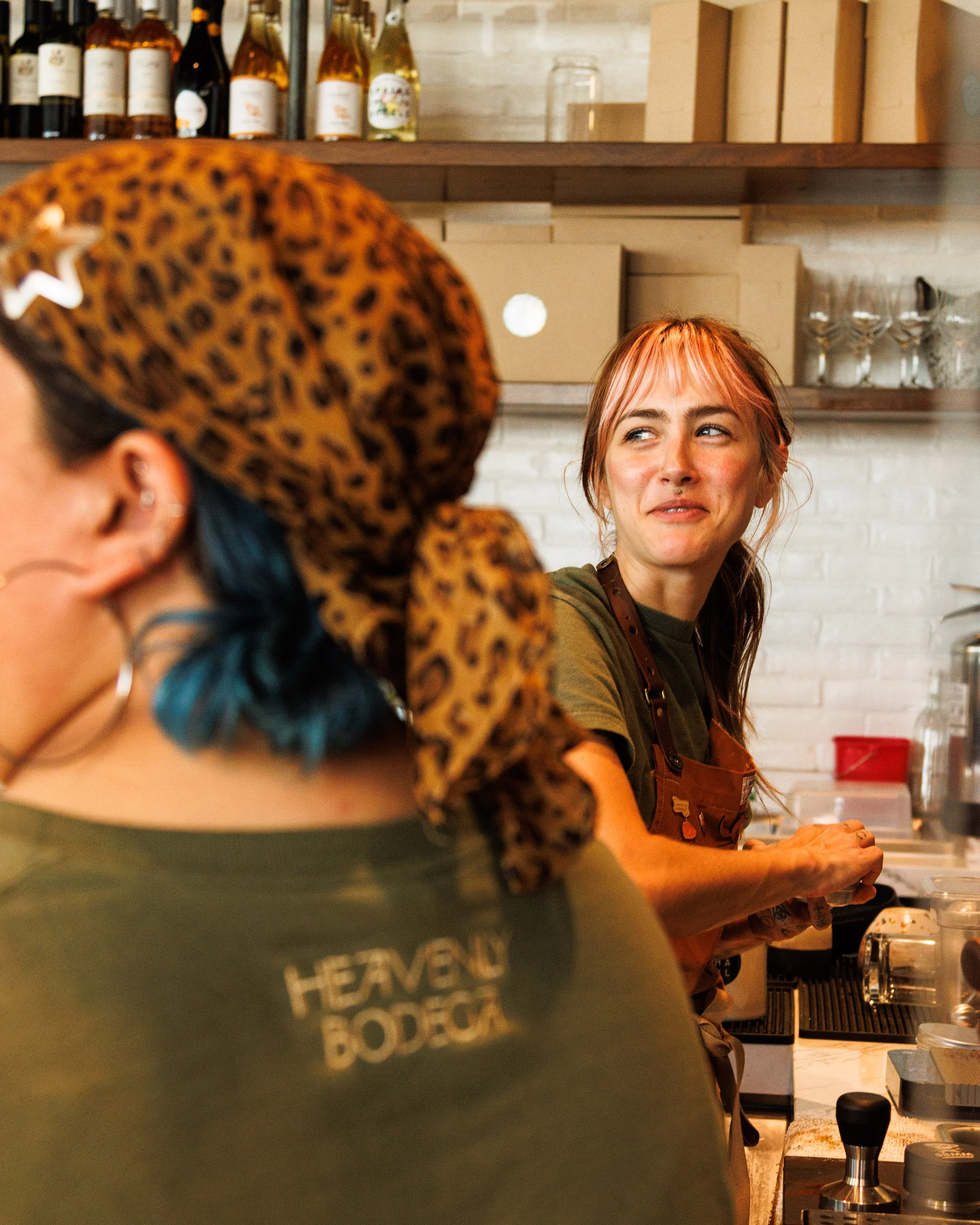 Commercial lifestyle photo of baristas laughing and making coffee for a hospitality brand.