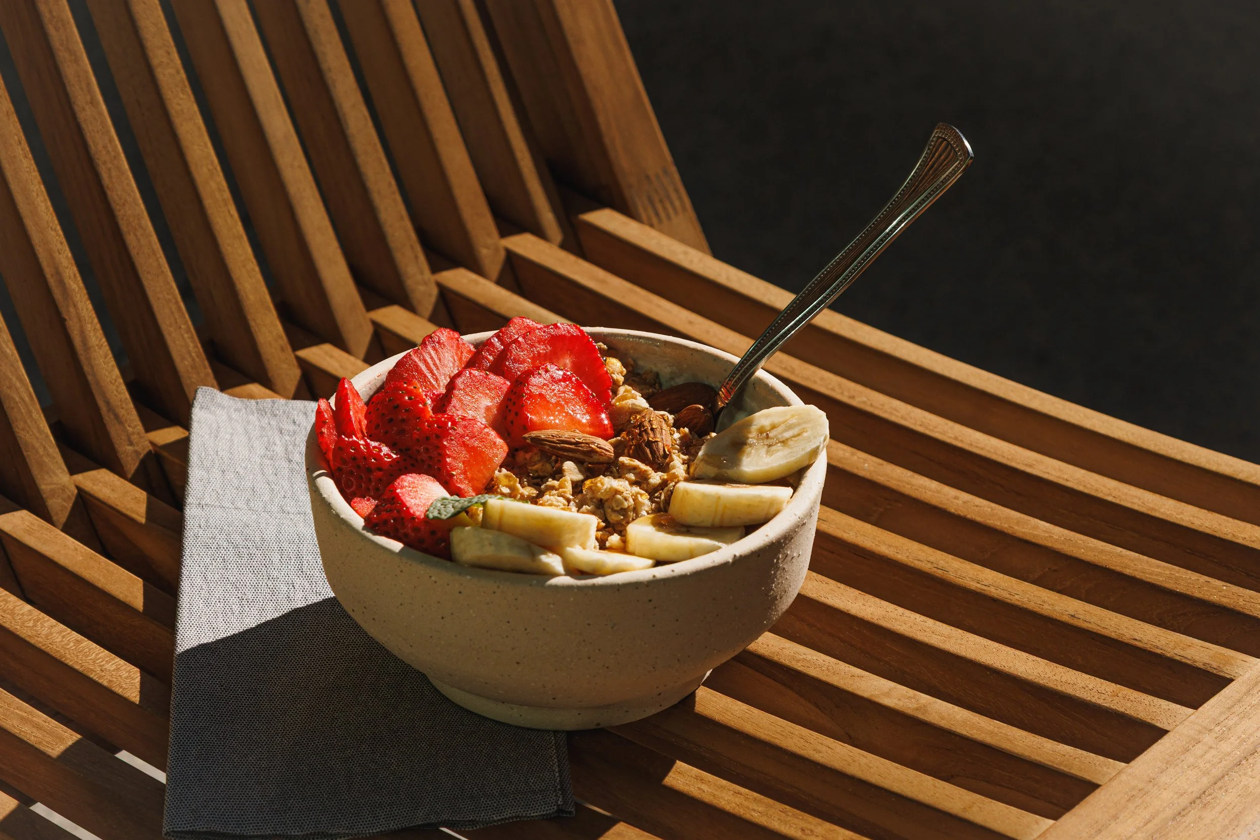 Commercial food photo of a bowl of yogurt with granola and fruit for a hospitality brand.