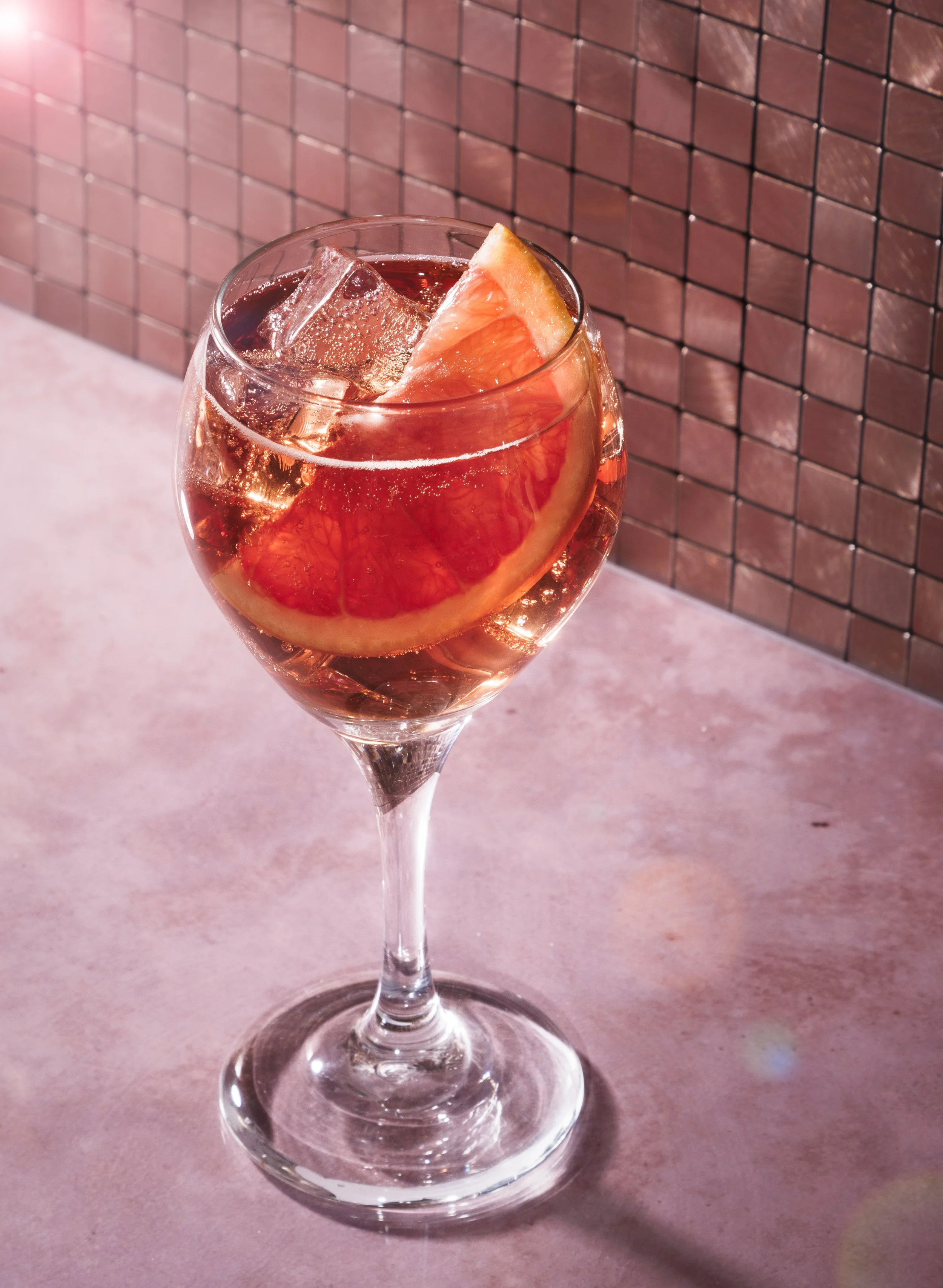 Commercial beverage photo of lillet wine with a grapefruit slice.