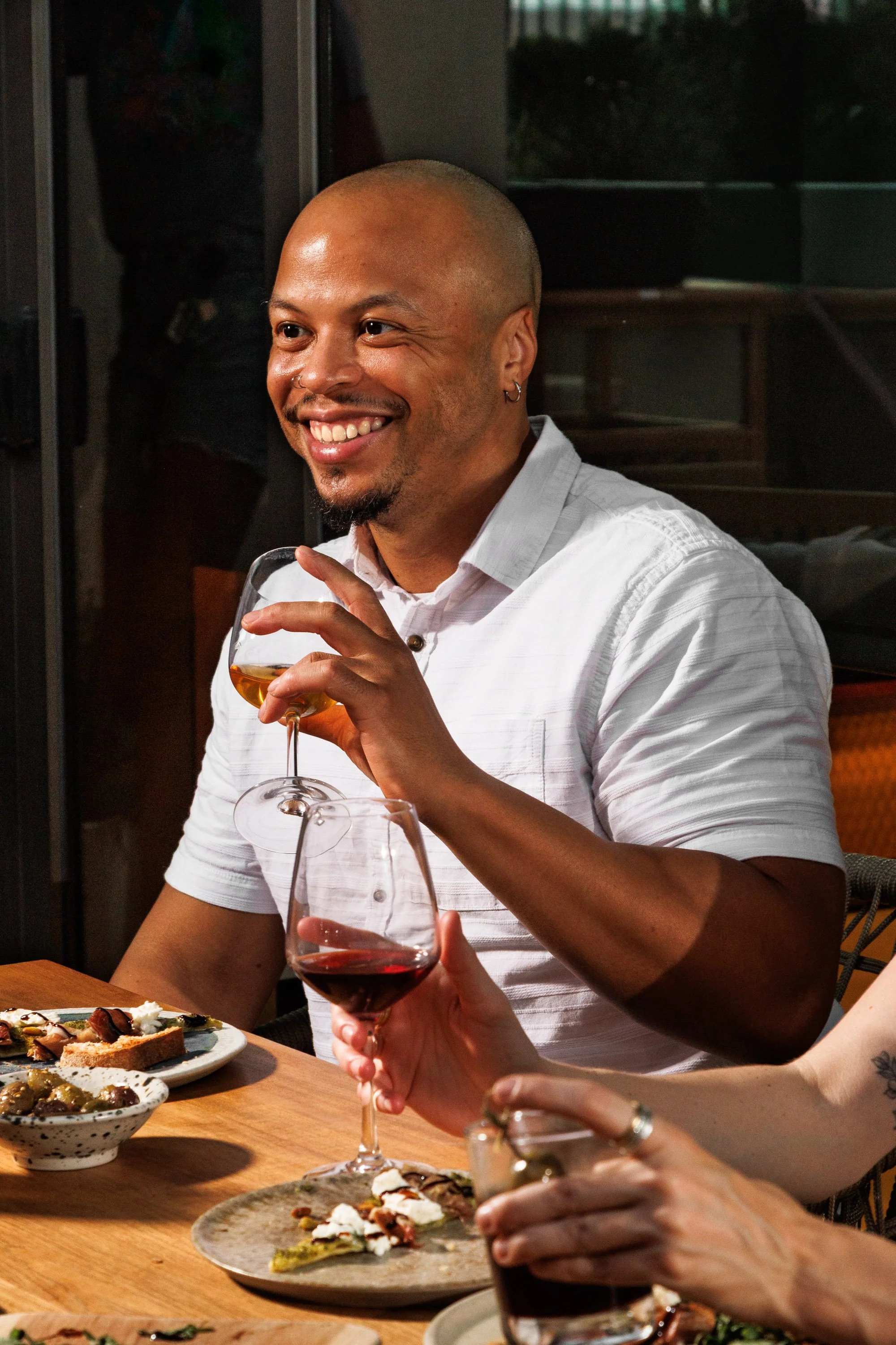 Commercial lifestyle photo of a man drinking wine and eating for a hospitality brand advertisement.